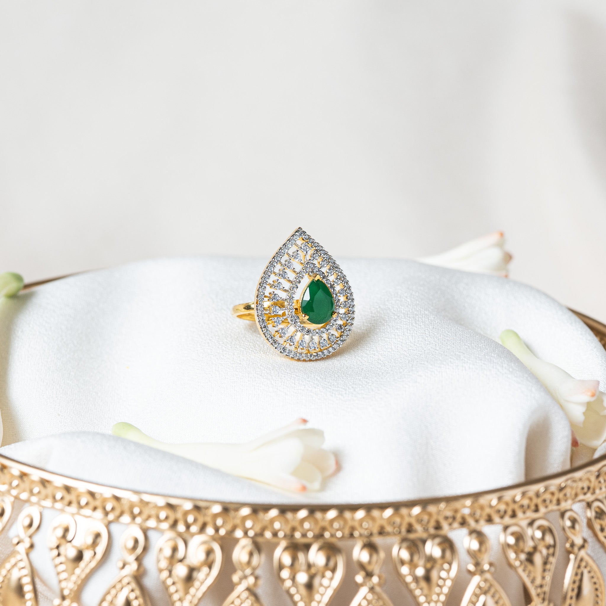 Front view of the CZ teardrop ring with gold spokes radiating from the green centre stone