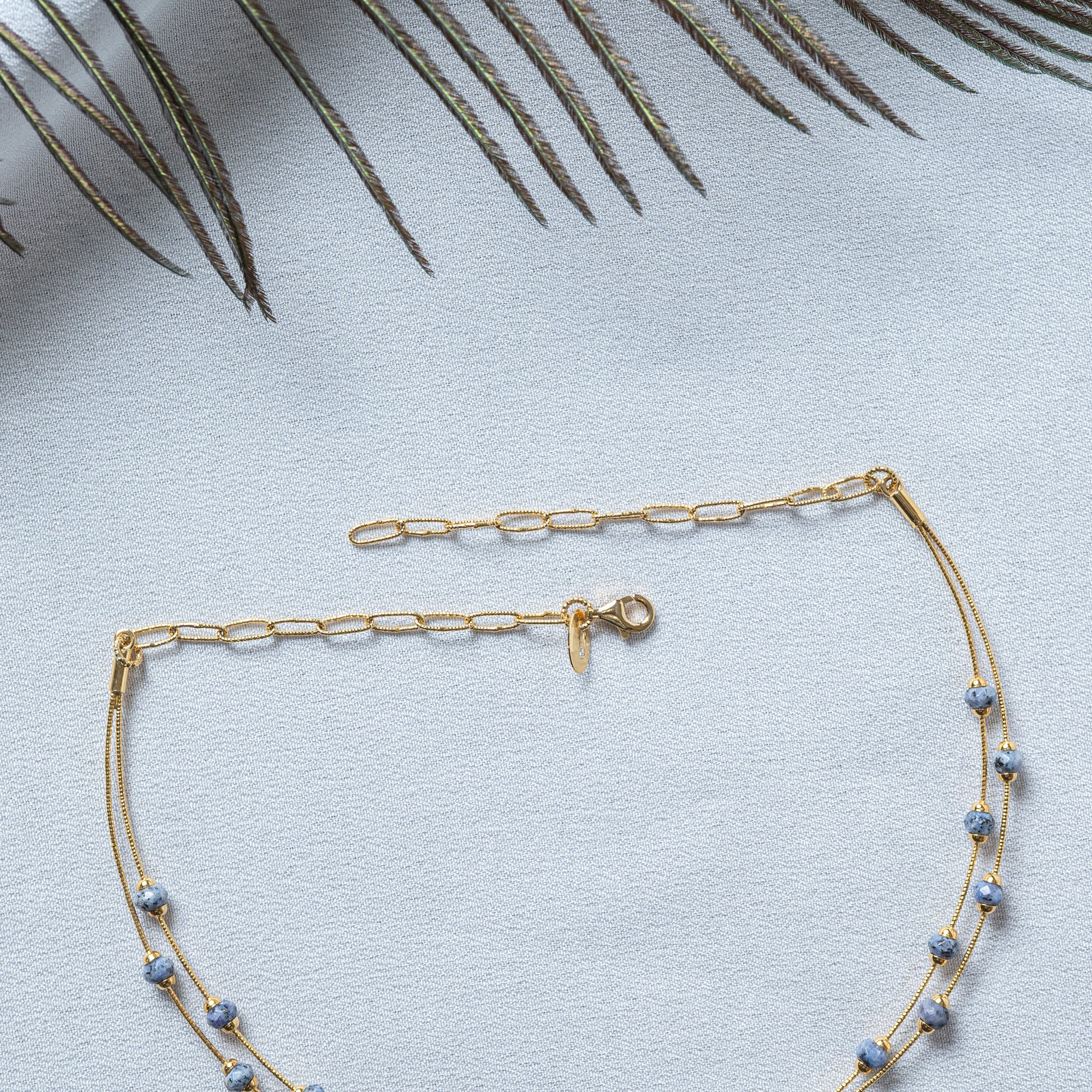 Both ends laid flat, gold tube connectors, lobster clasp with leaf tag and oval extender