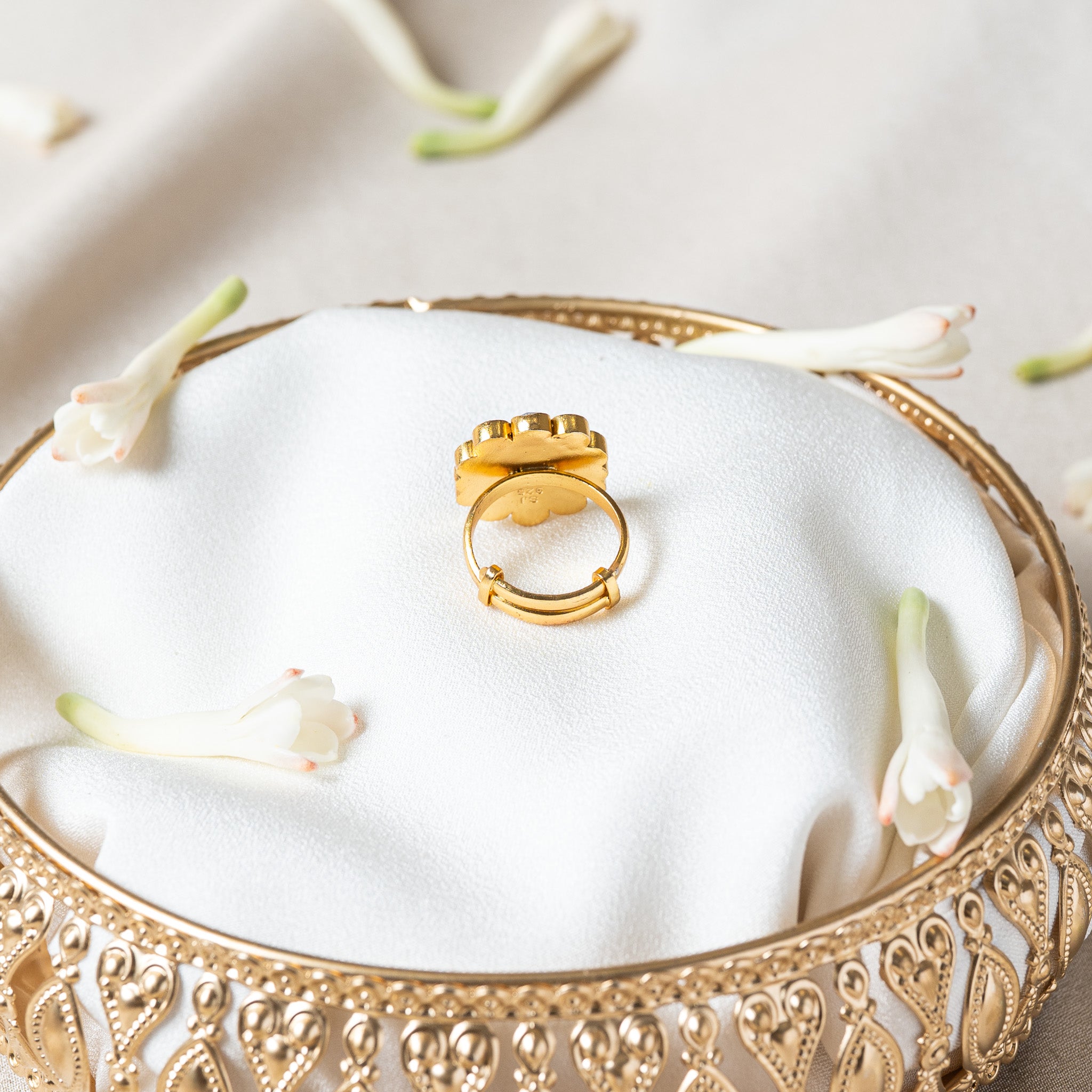 Underside of the kundan ring showing the sliding band tail passing through two gold loops