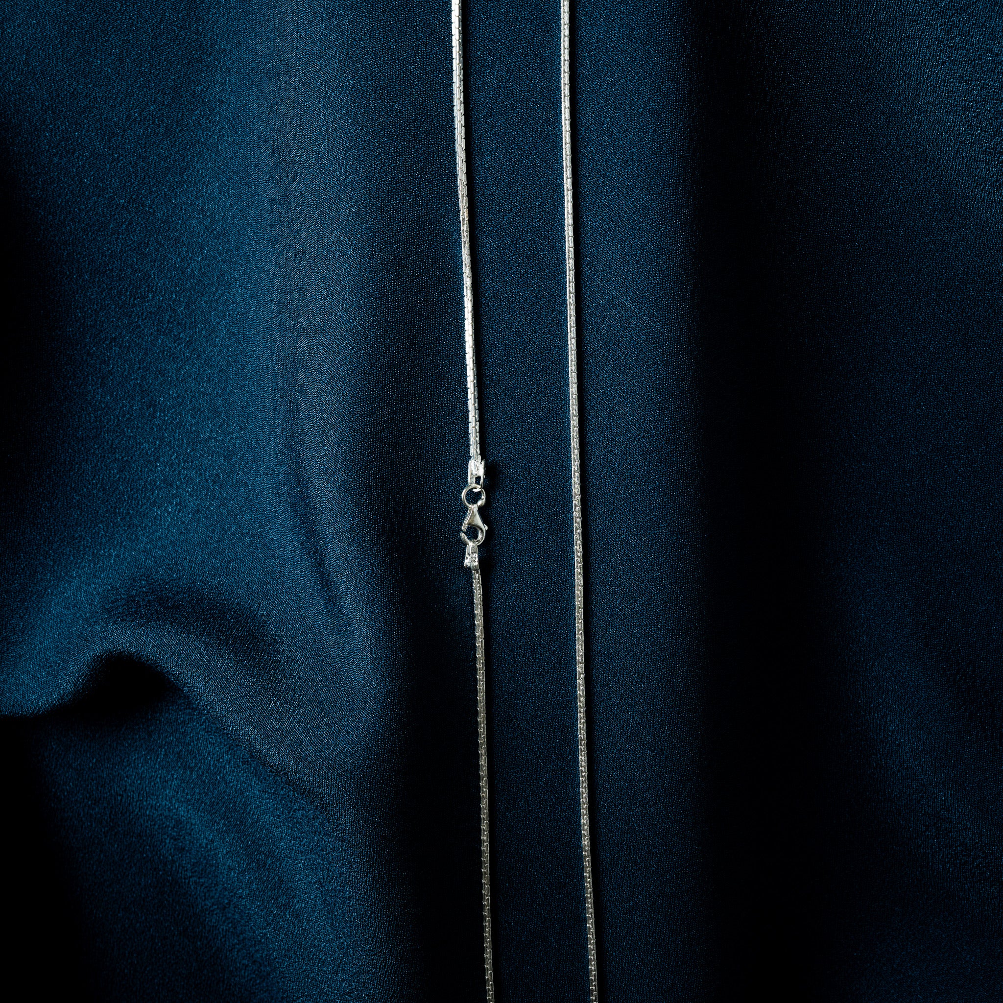 Close crop of faceted box links on a 925 silver neckchain