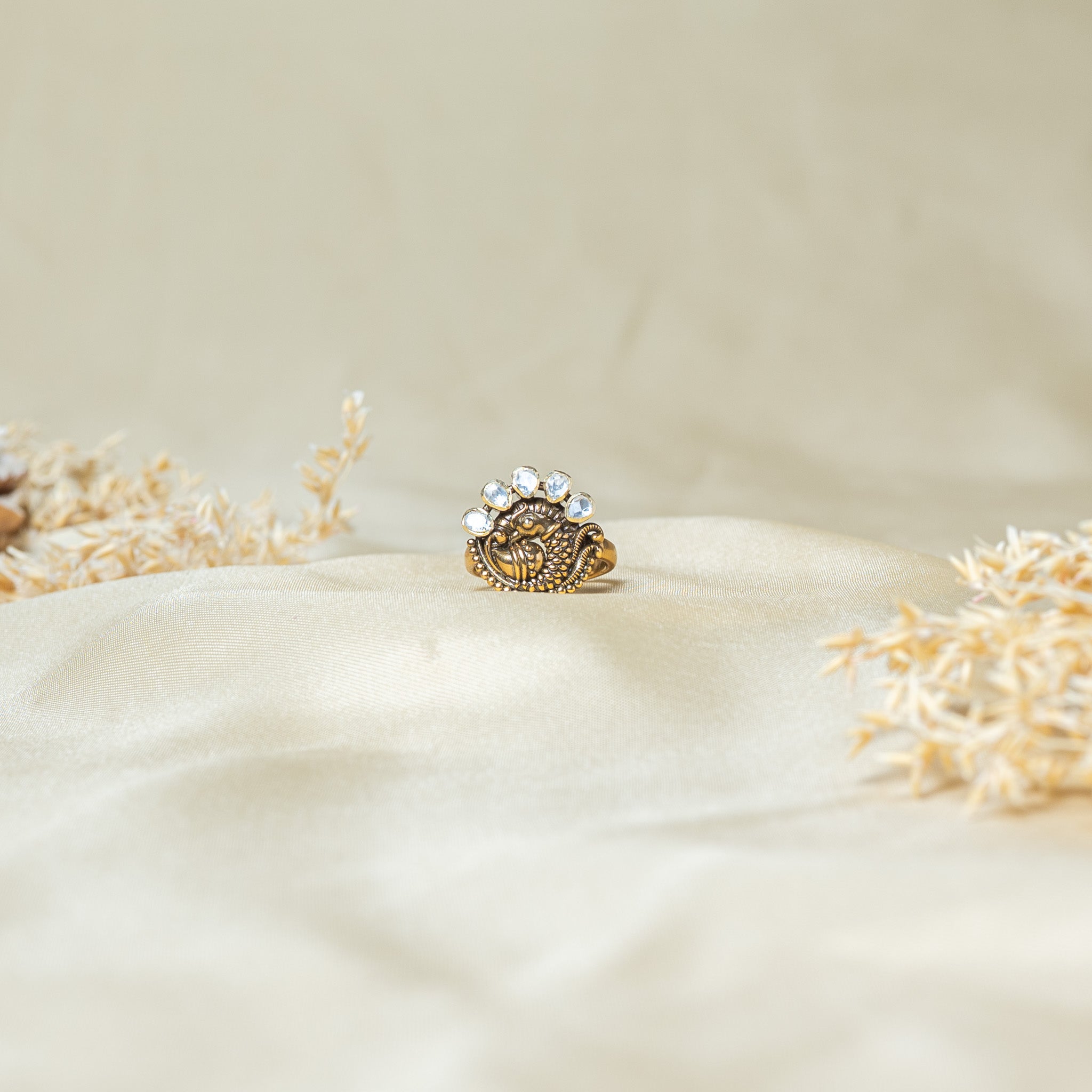 Front view of the raised peacock body in rows of granulation with the uncut stone tail above
