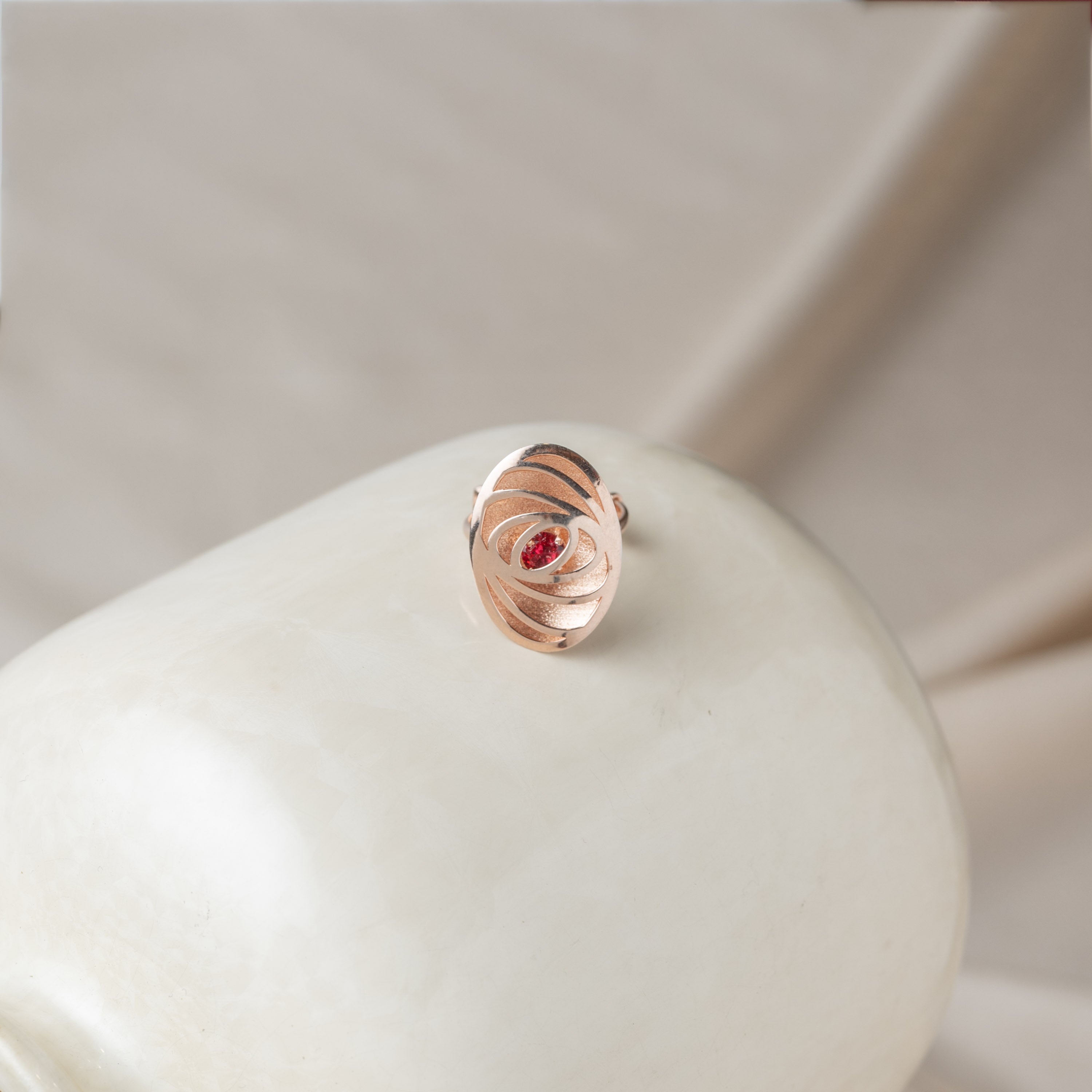 Close view of the carved ridges turning in on the ruby, rose gold plated 925 silver