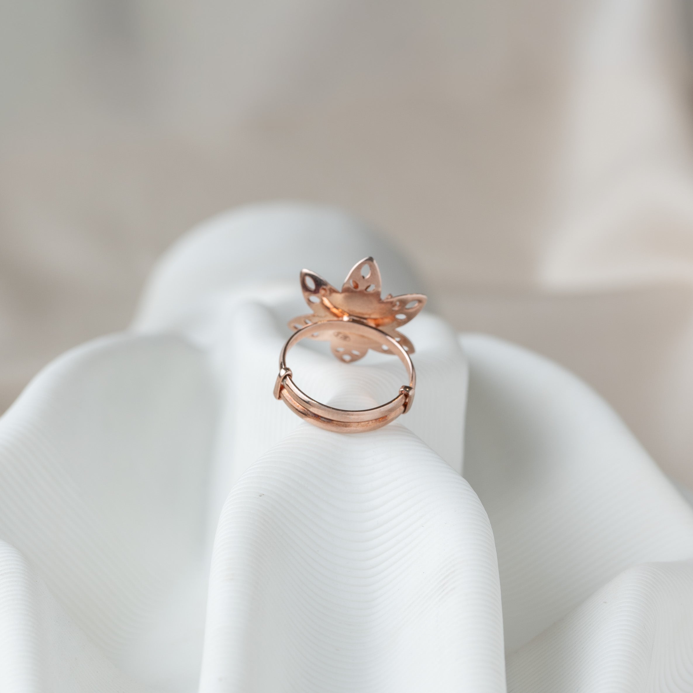 Underside of the flower ring showing the open sliding band in rose gold plated 925 silver