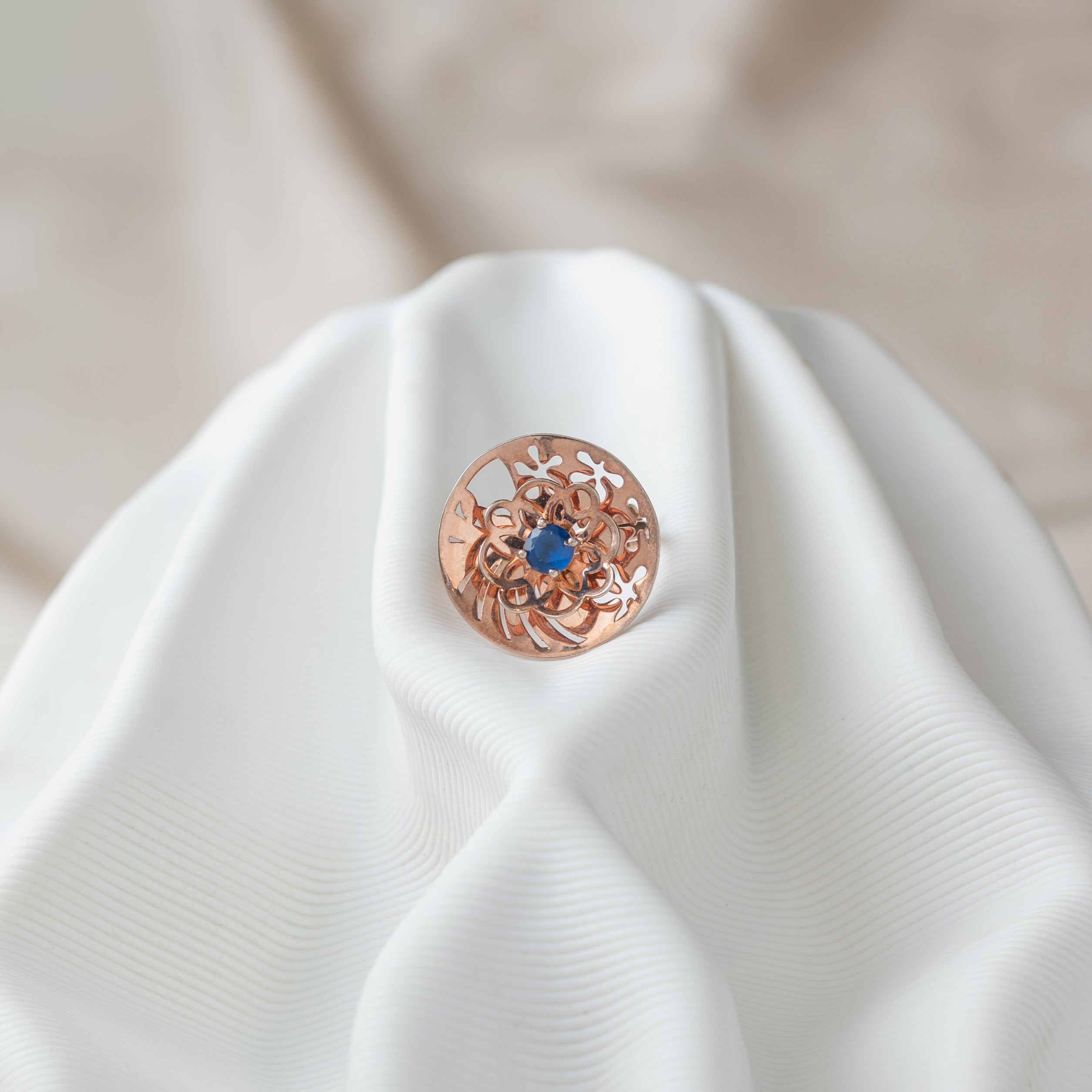 Round jaali disc ring with a blue sapphire in the centre flower, rose gold plated 925 silver