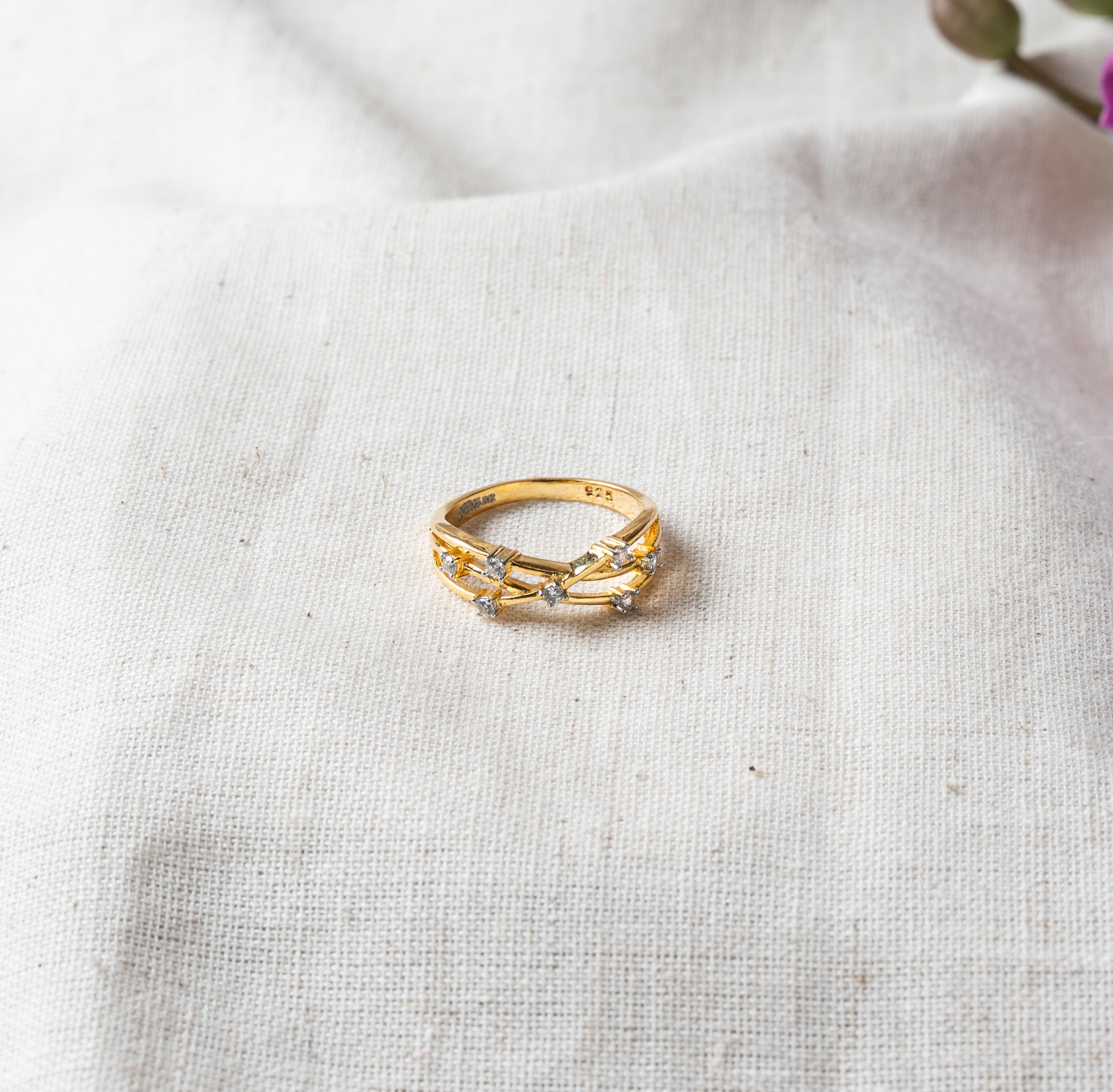Twist band ring with CZ set where the strands cross in gold plated 925 silver