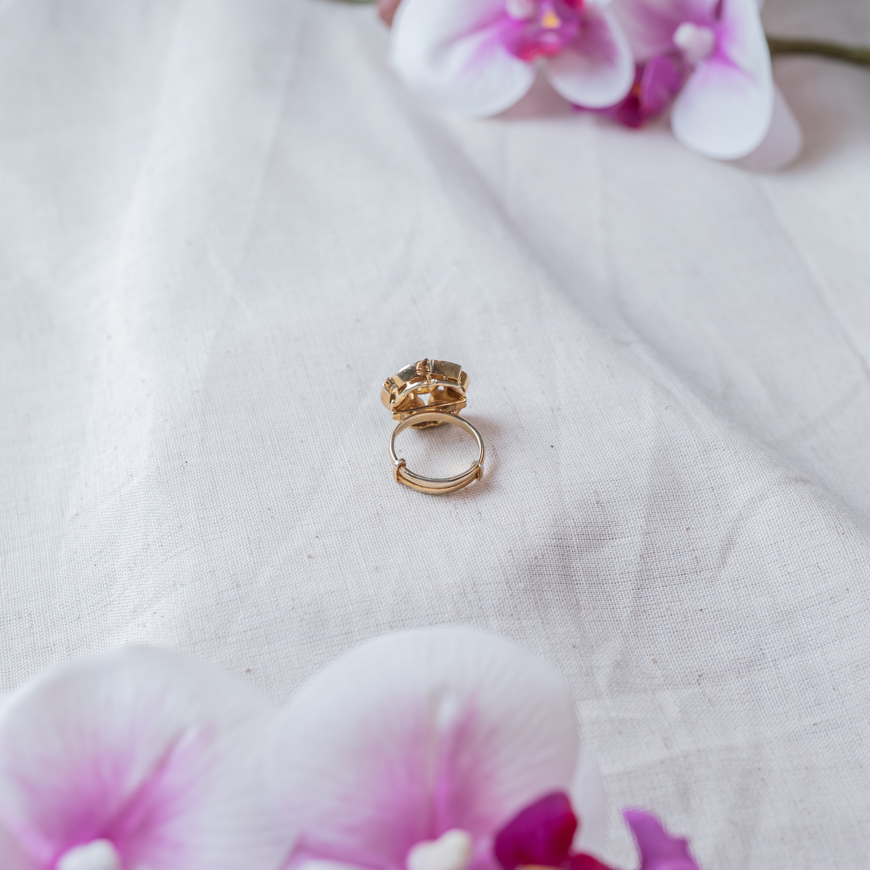 Close view of the plain adjustable gold plated shank behind the five petal polki head