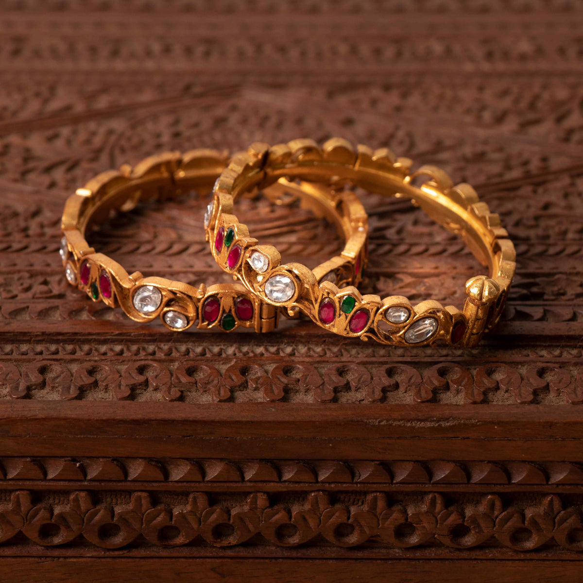 Floral vine bangle with white kundan ovals and red and green accents, gold plated silver