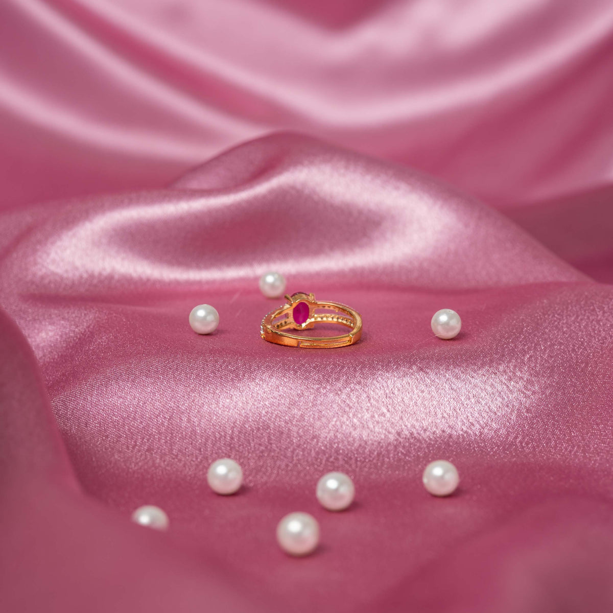 Close crop of the open adjustable back behind the red oval and white CZ ring