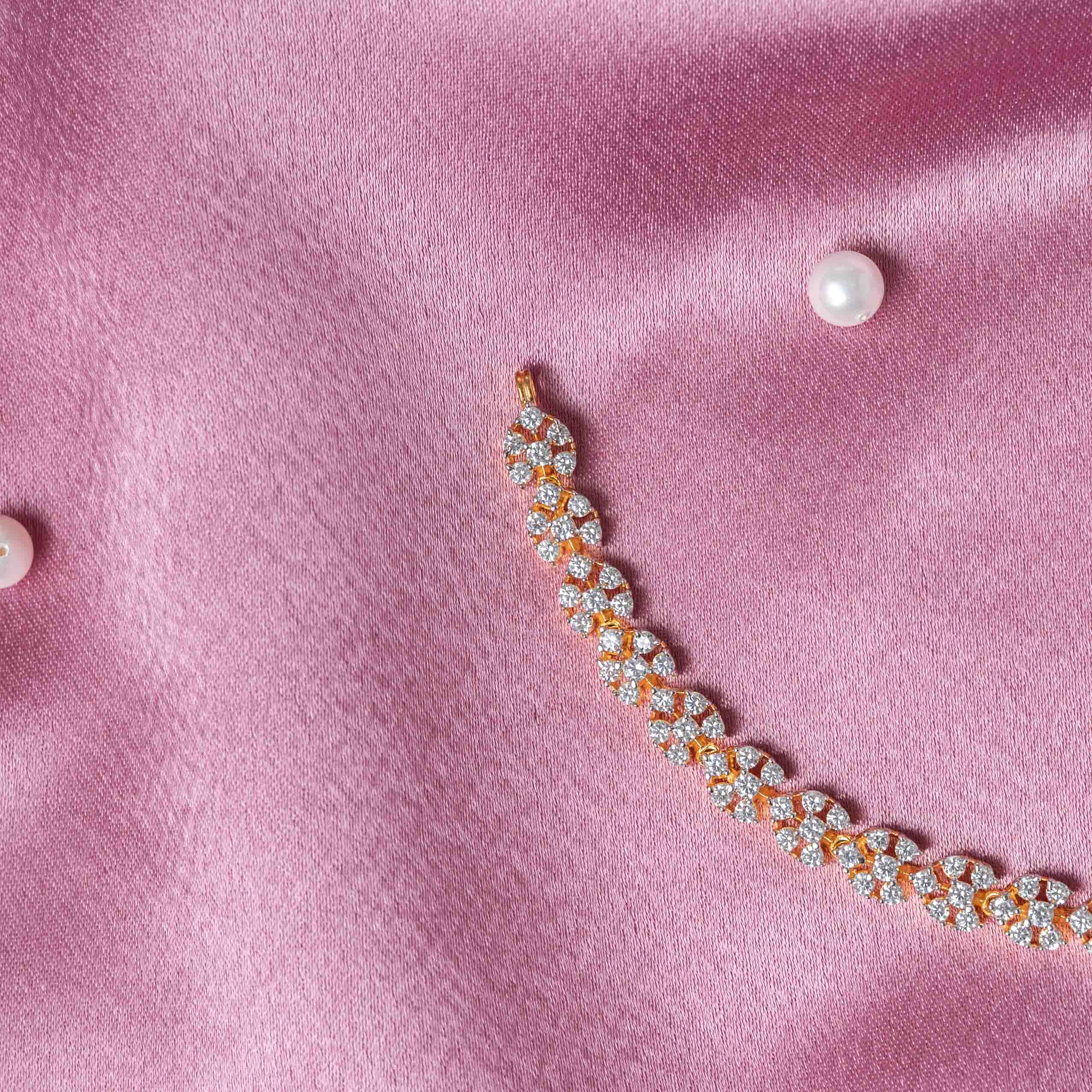 Close crop of the floral CZ links along the necklace curve in gold plated silver