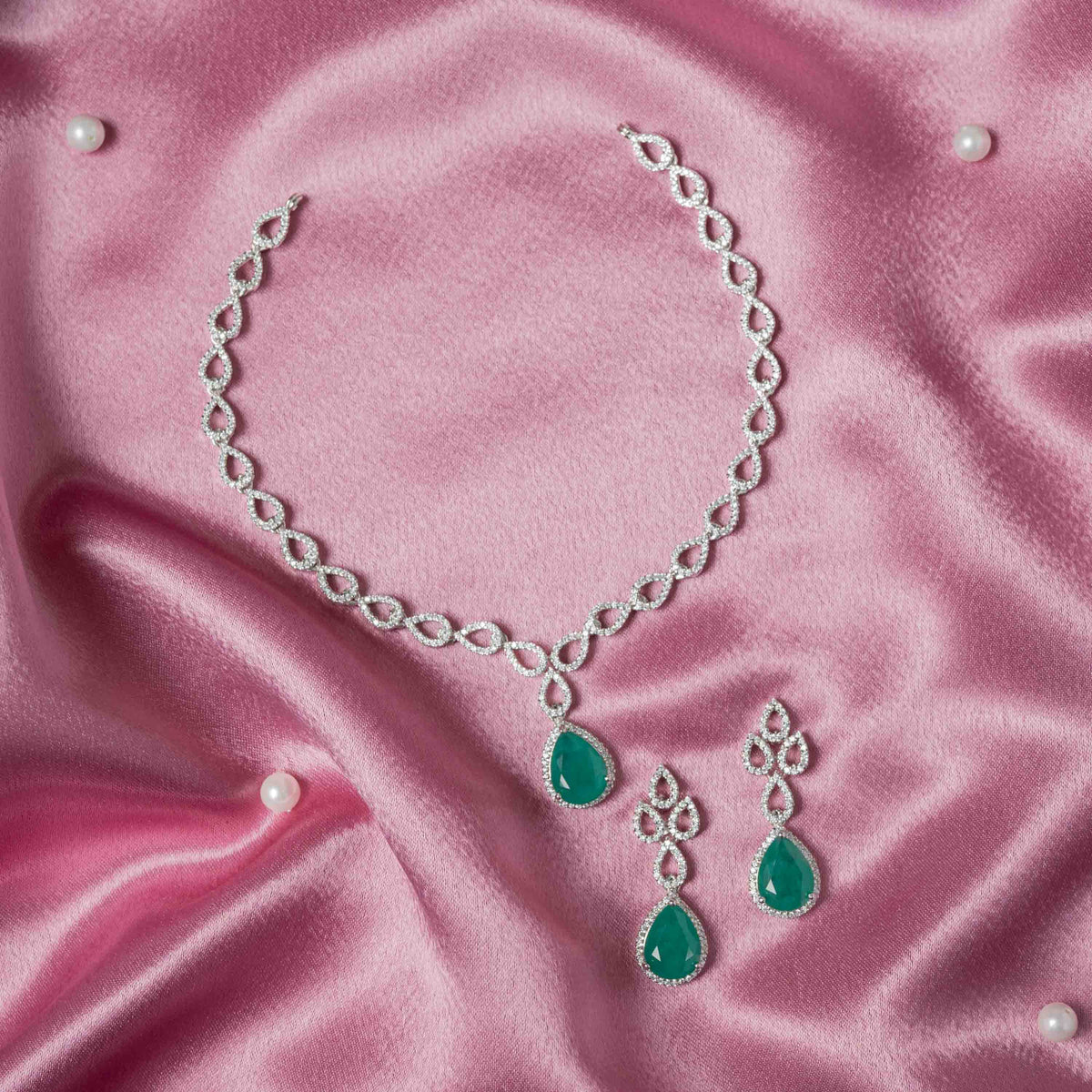 Close view of the dori tie behind the geometric CZ and green teardrop necklace