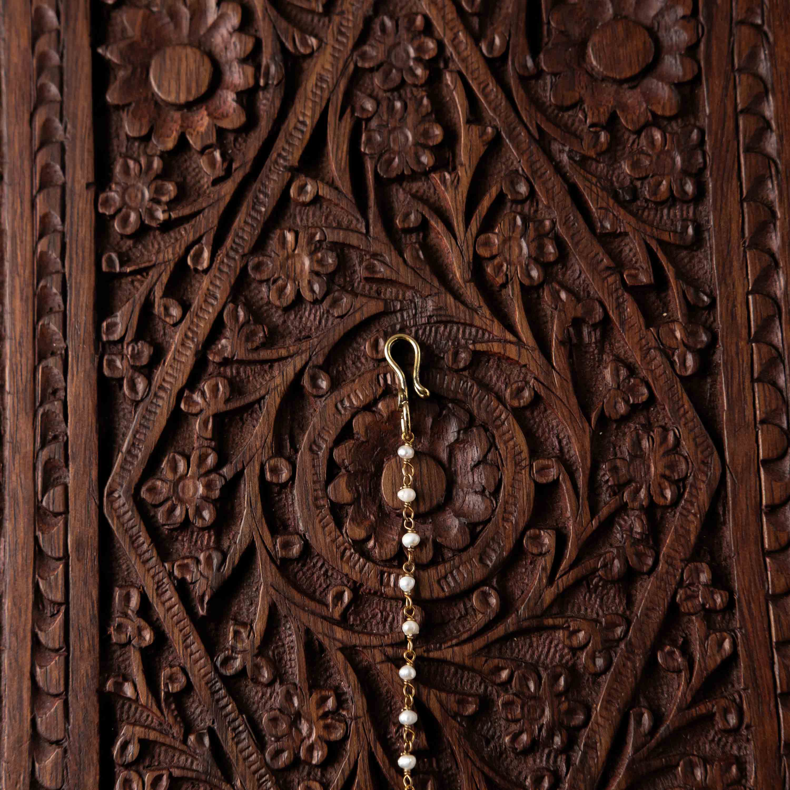 Pearl chain and fish hook behind the marquise polki maangtika in Victorian finish silver