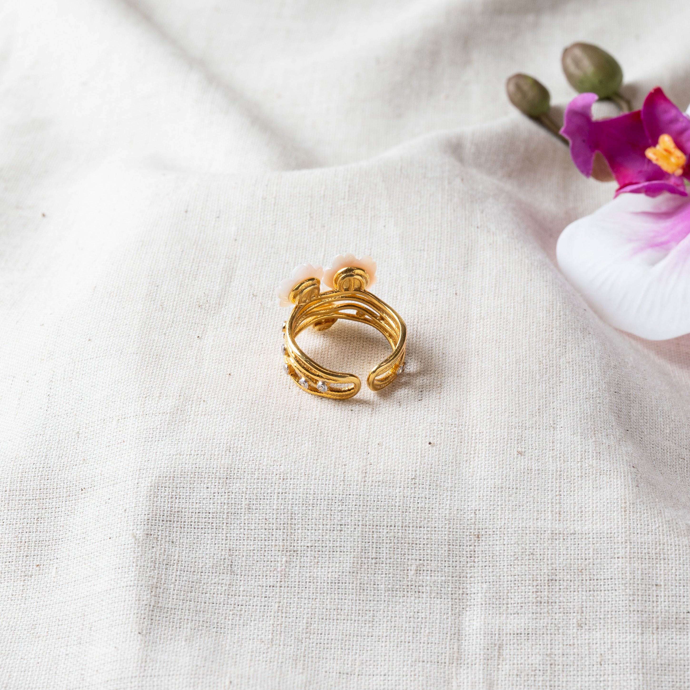 Close view of the carved mother of pearl flowers on the CZ set double band in gold plated silver