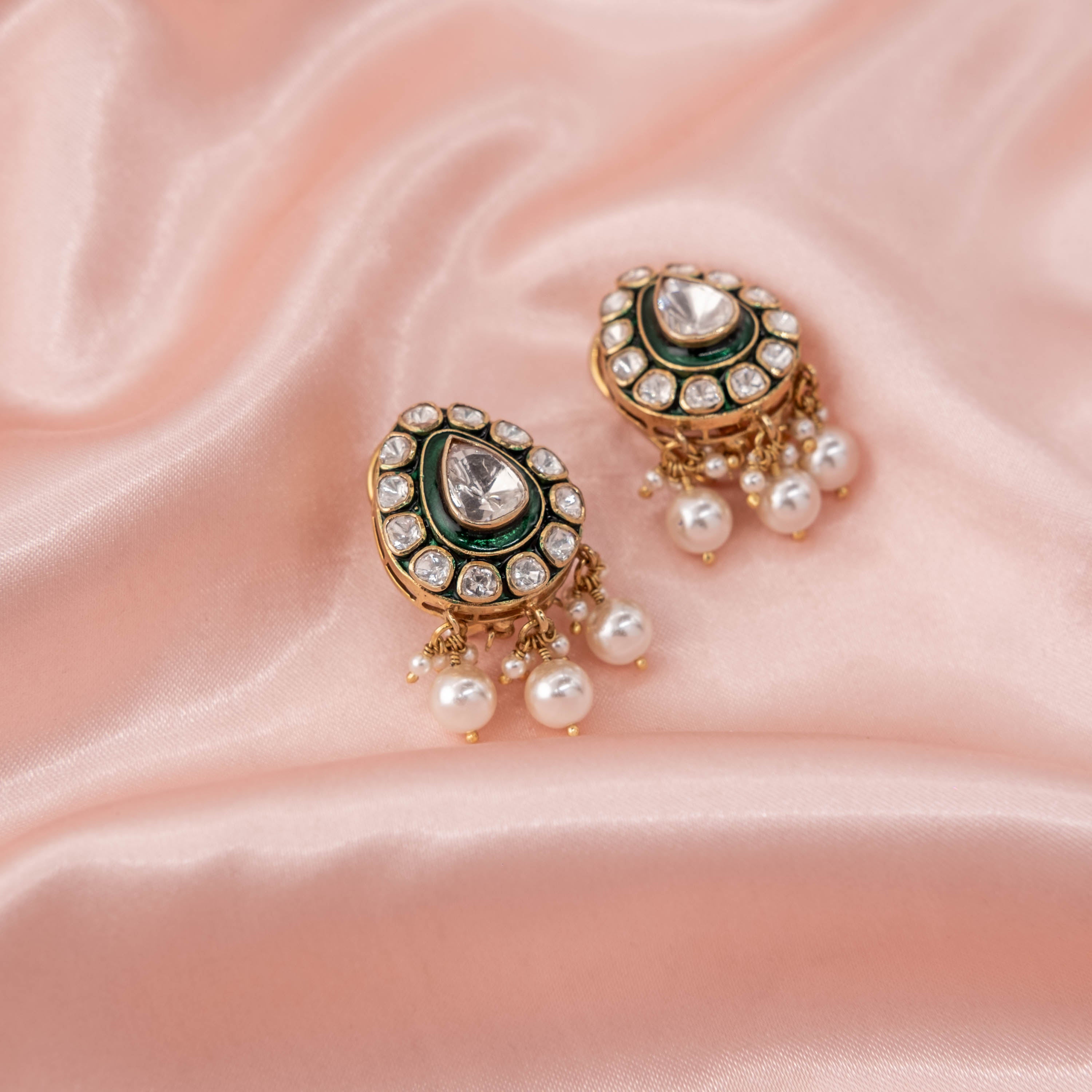 Front view of Zehra Green Polki stud earrings featuring teardrop Moissanite Polki, green enamel detailing, CZ halo and pearl drops in 925 sterling silver