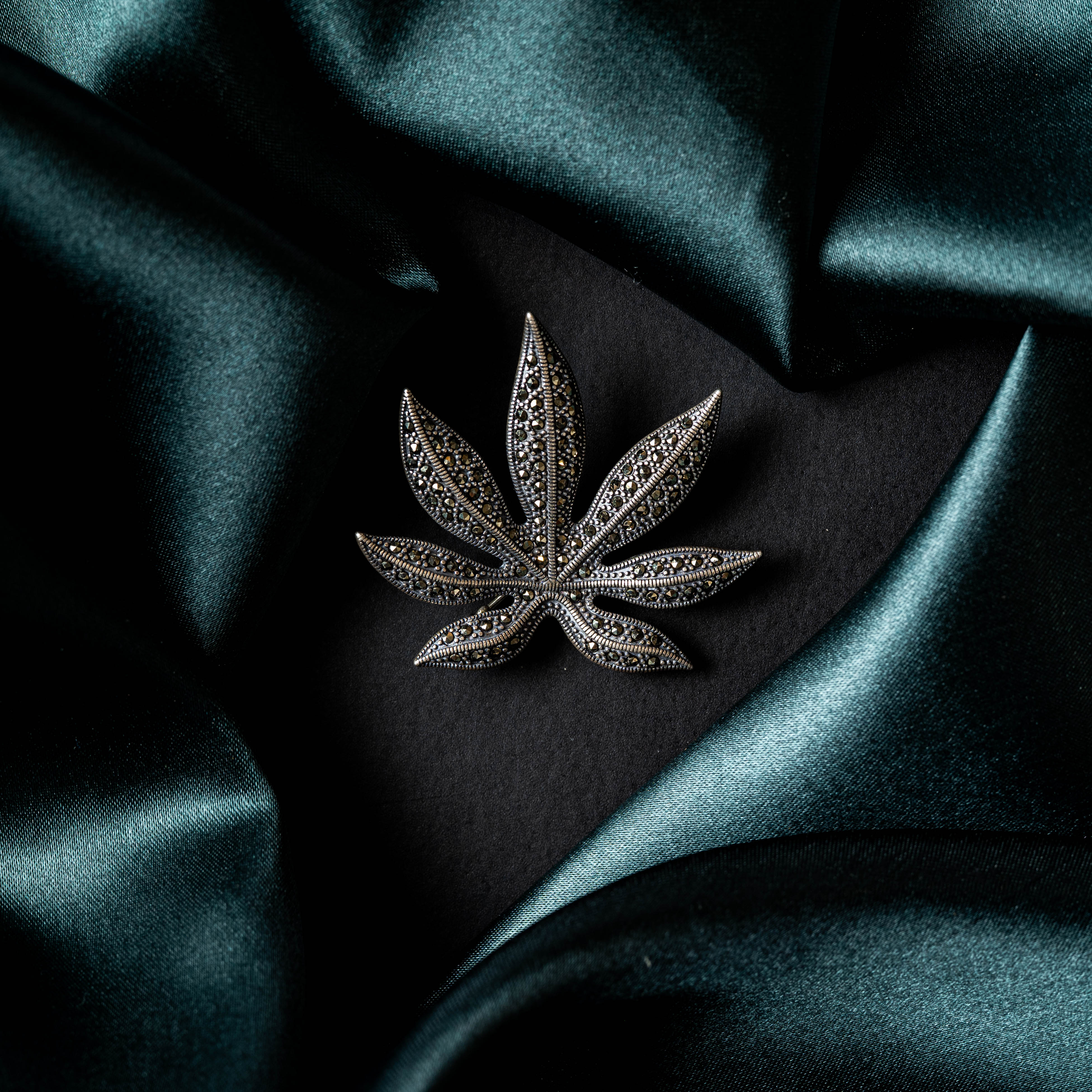 Back of the leaf brooch showing the smooth silver reverse and pin bar