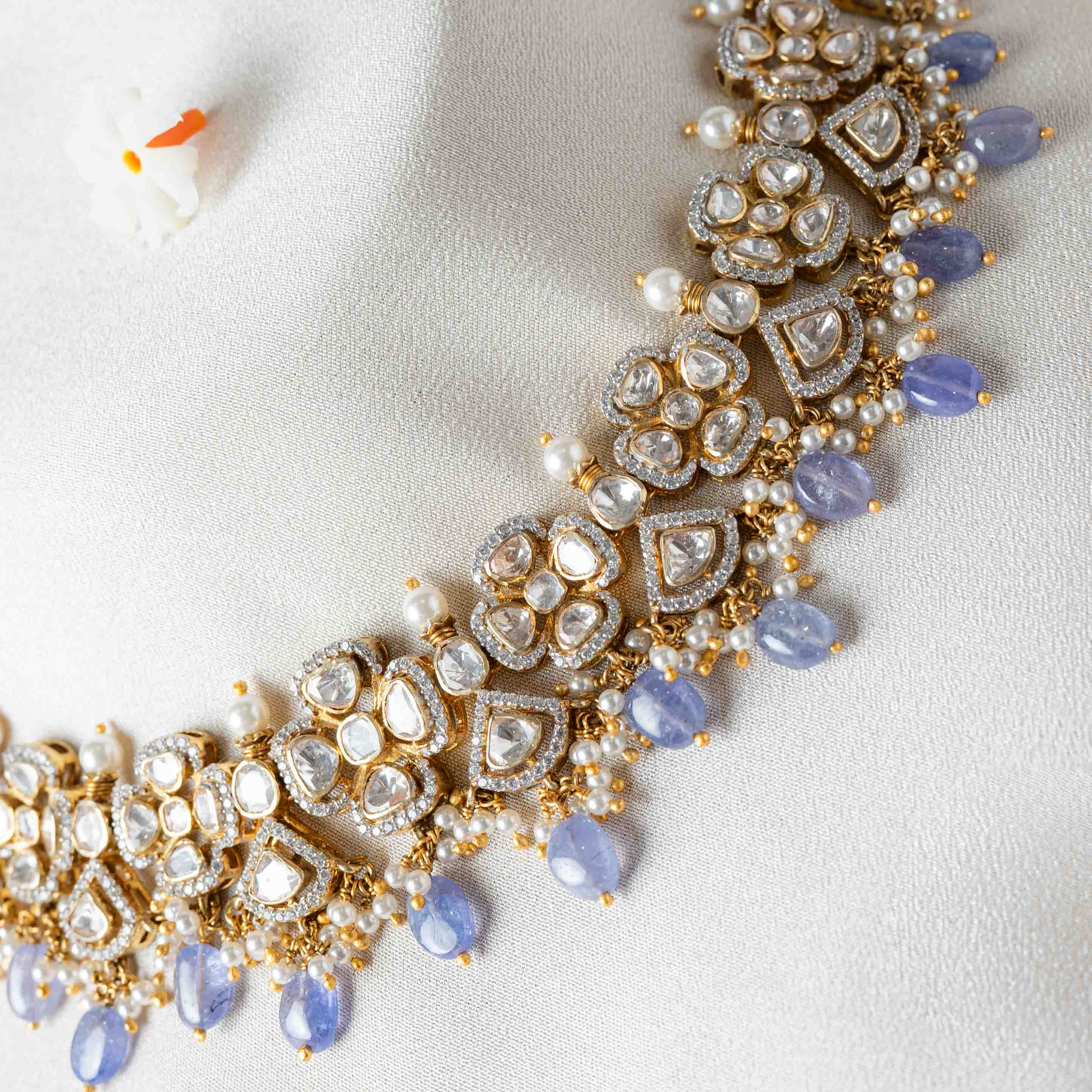 Close-up of Niya Polki Necklace showcasing intricate Moissanite Polki motifs with white CZ detailing, pearl accents and pastel strawberry bead drops in gold-plated 925 silver.
