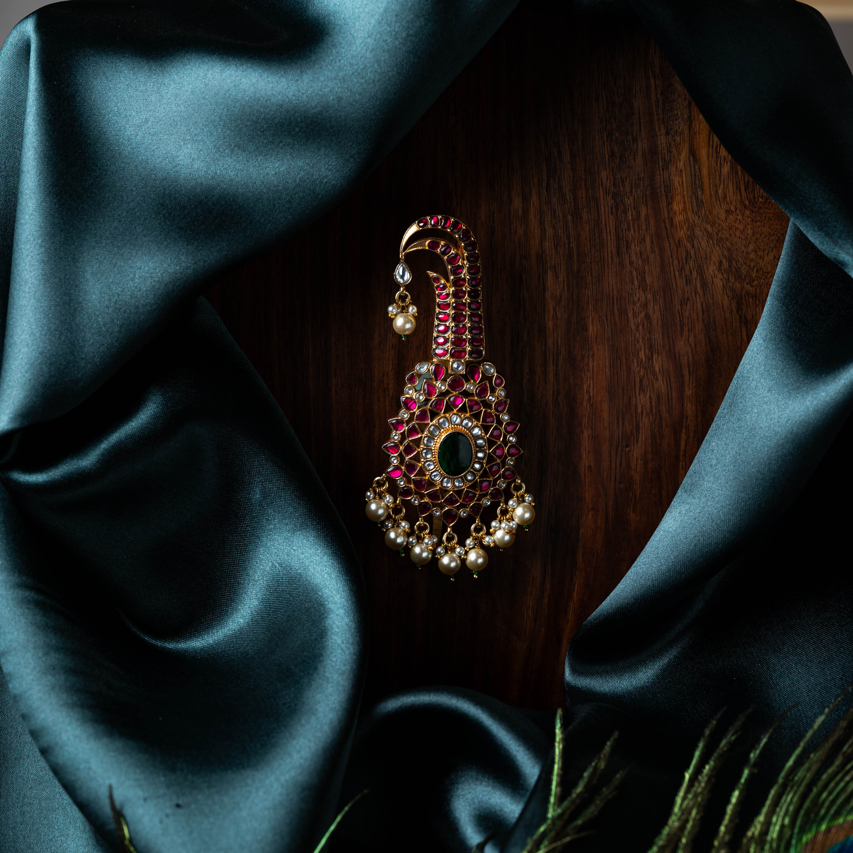 Close view of the pink kundan rows and green centre stone with the pearl fringe below