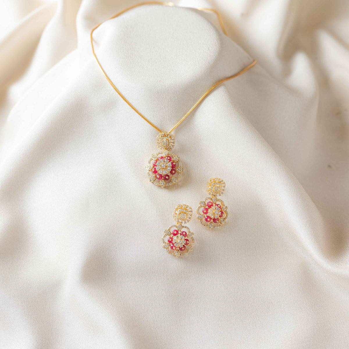 Close crop of the Bombay screw back behind a red bead CZ hanging earring in gold plated silver