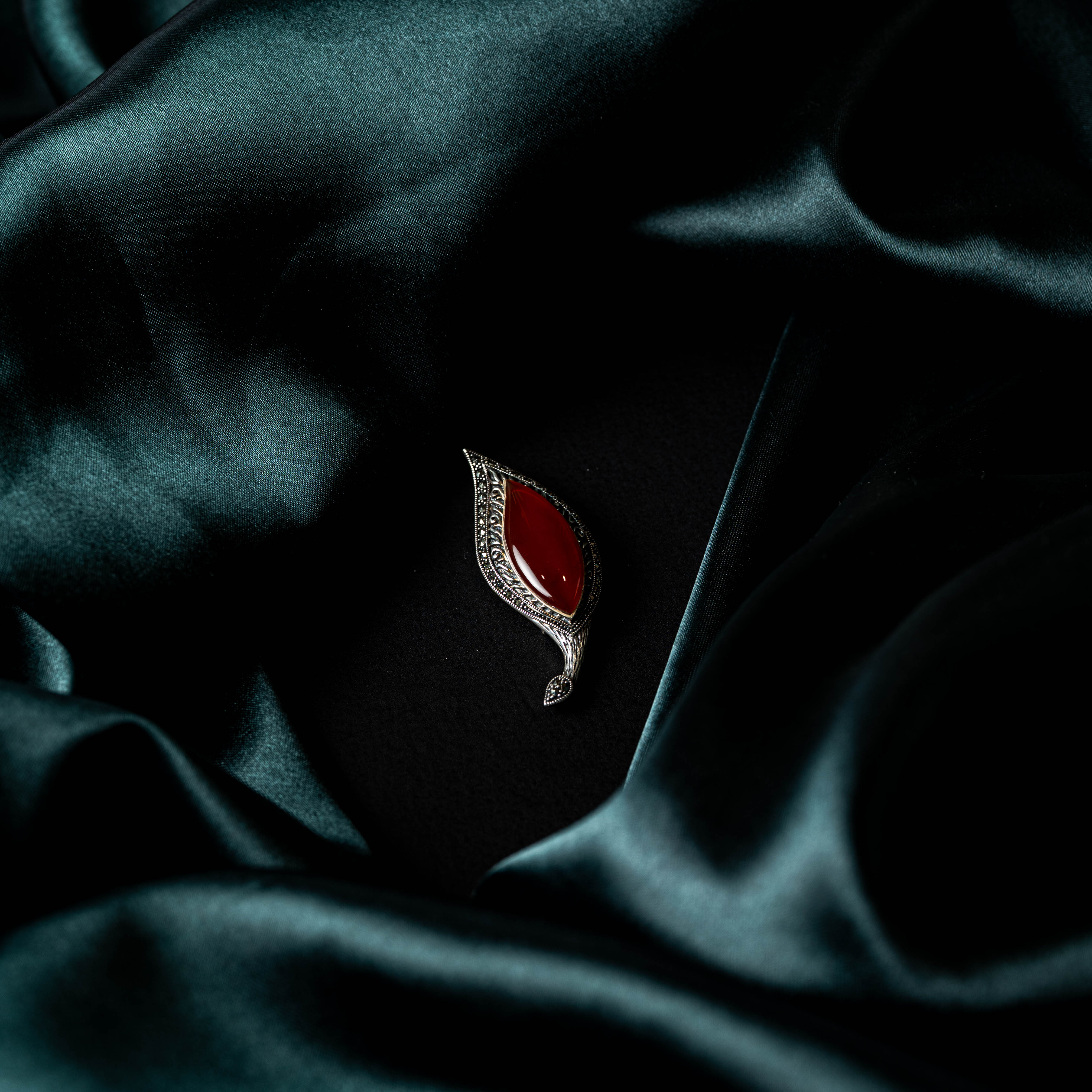 Angled close view of the red onyx and the marcasite paisley outline around it