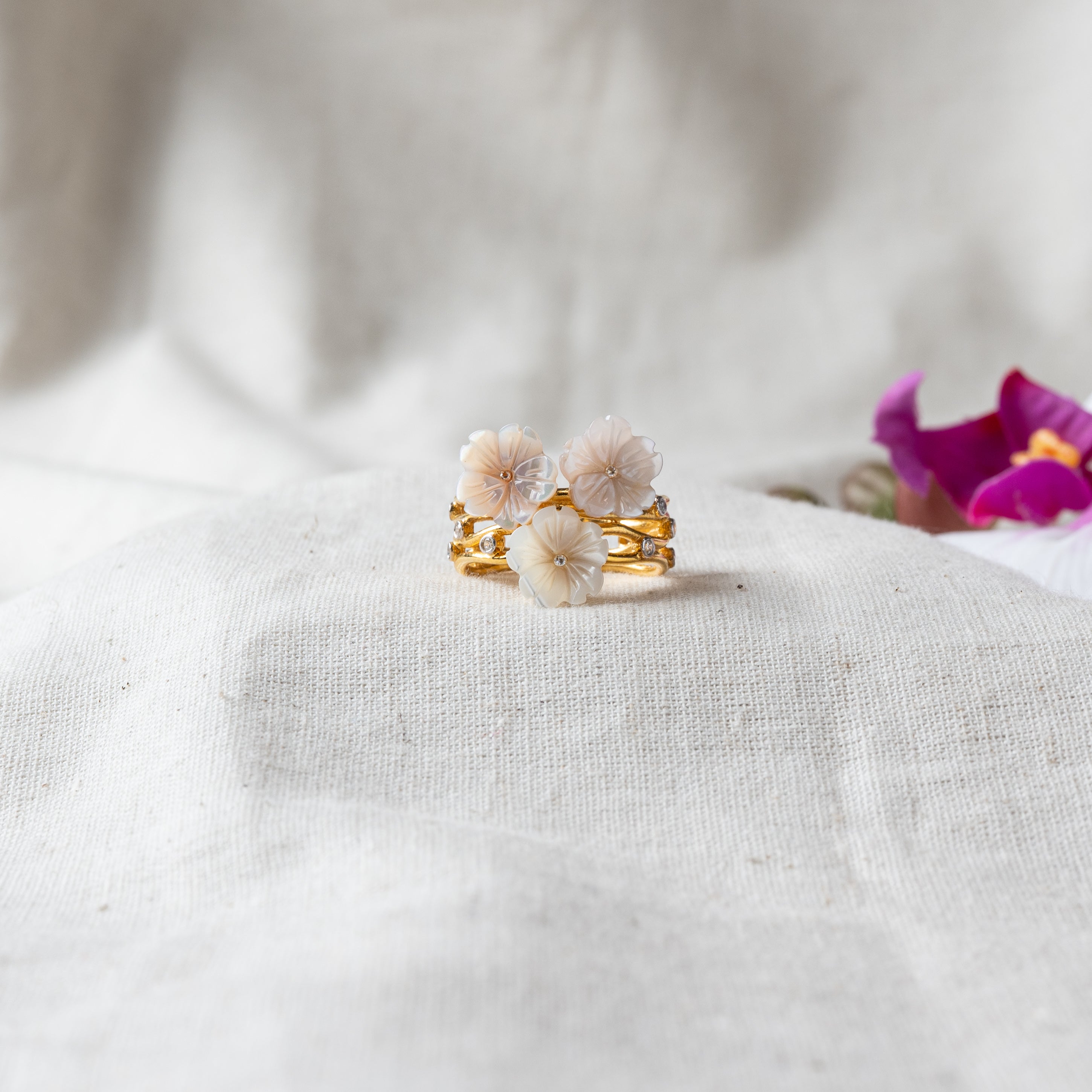 Ring with three carved mother of pearl flowers and CZ accents in gold plated 925 silver