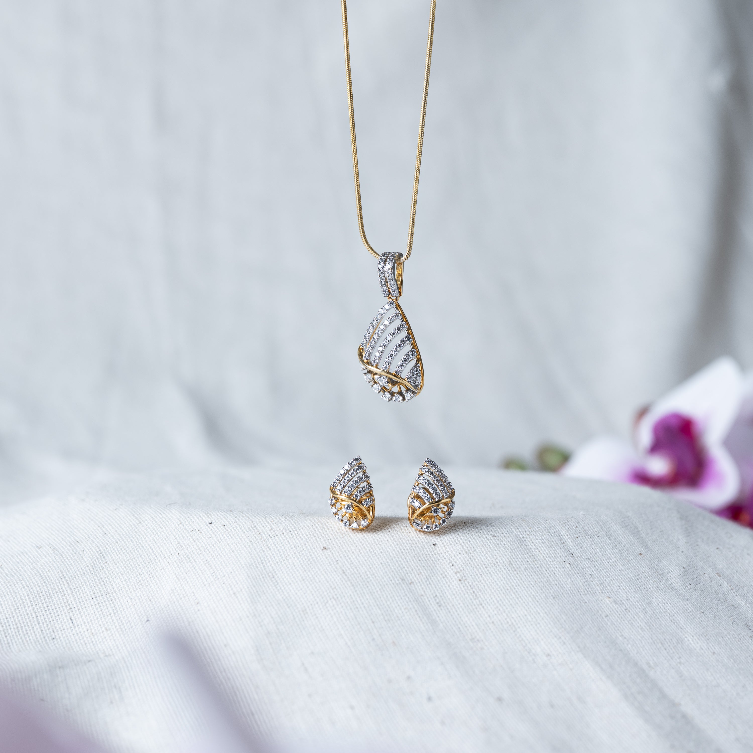 Twist pendant on its chain shown above the matching CZ studs of the set in 925 silver