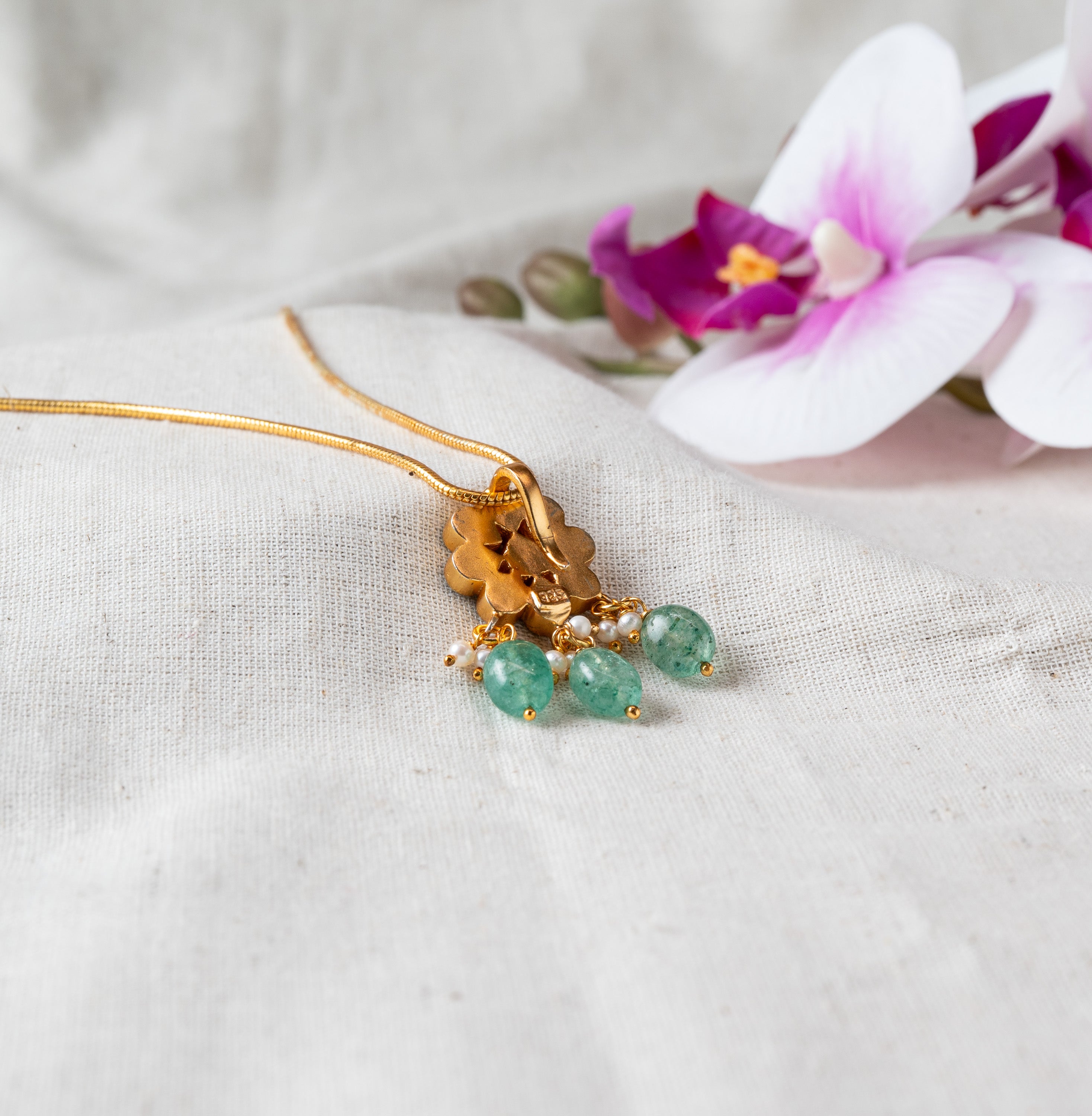 Back view of the floral pendant showing plain gold plated 925 silver behind the green bead drops