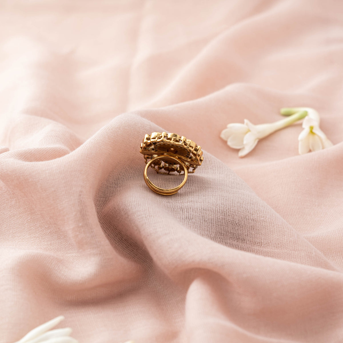 Side view of the round cocktail ring showing the coral centre and adjustable band, gold plated silver