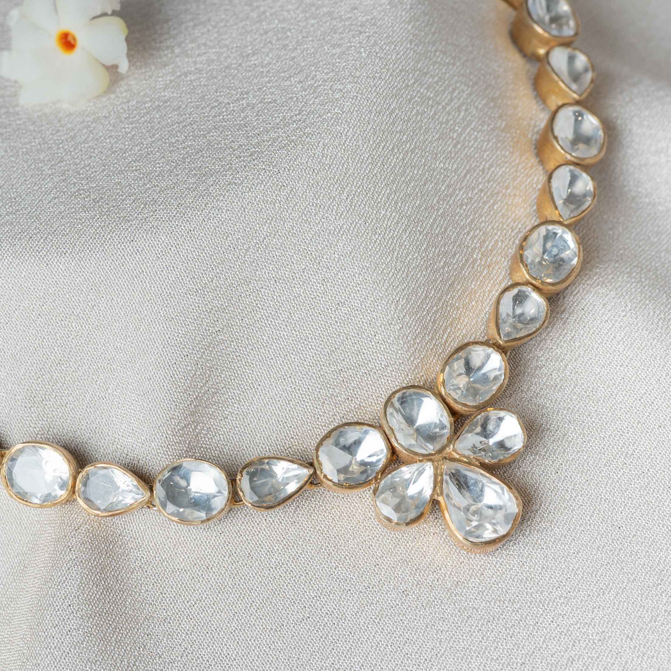 Close-up of Aarna Polki Necklace showcasing large Moissanite Polki stones in minimalist gold bezels with an elegant floral pendant.