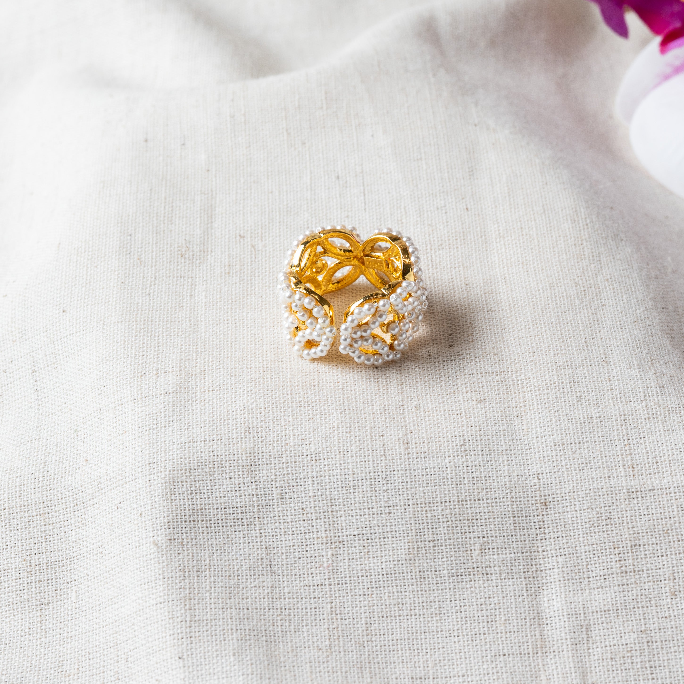 Angled view showing the open adjustable band beneath the pearl butterfly in gold plated 925 silver