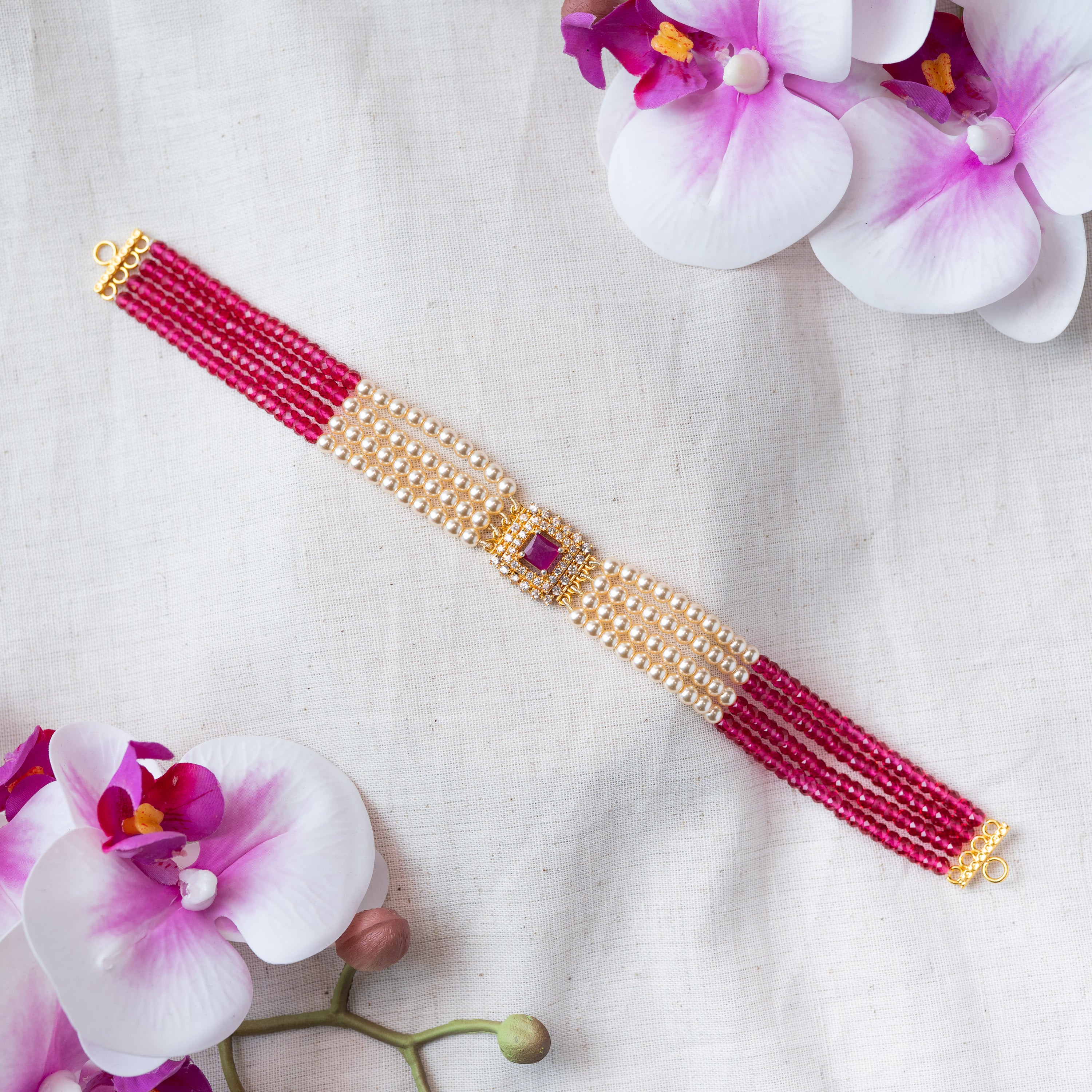 Ruby bead strands gathered into the gold plated end connector of the choker
