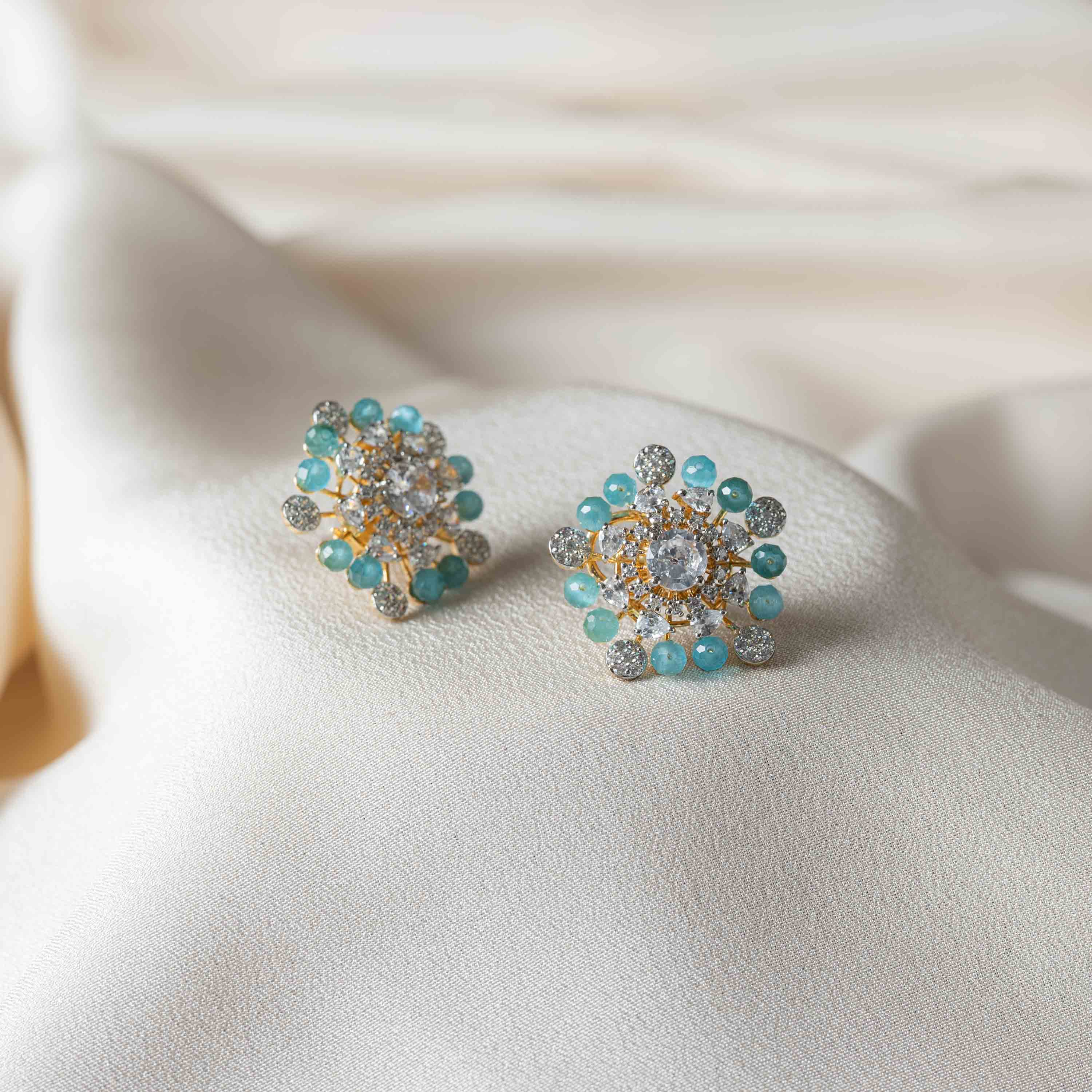 Siya CZ floral studs in 925 sterling silver with gold plating, sparkling CZ stones and blue-green bead accents