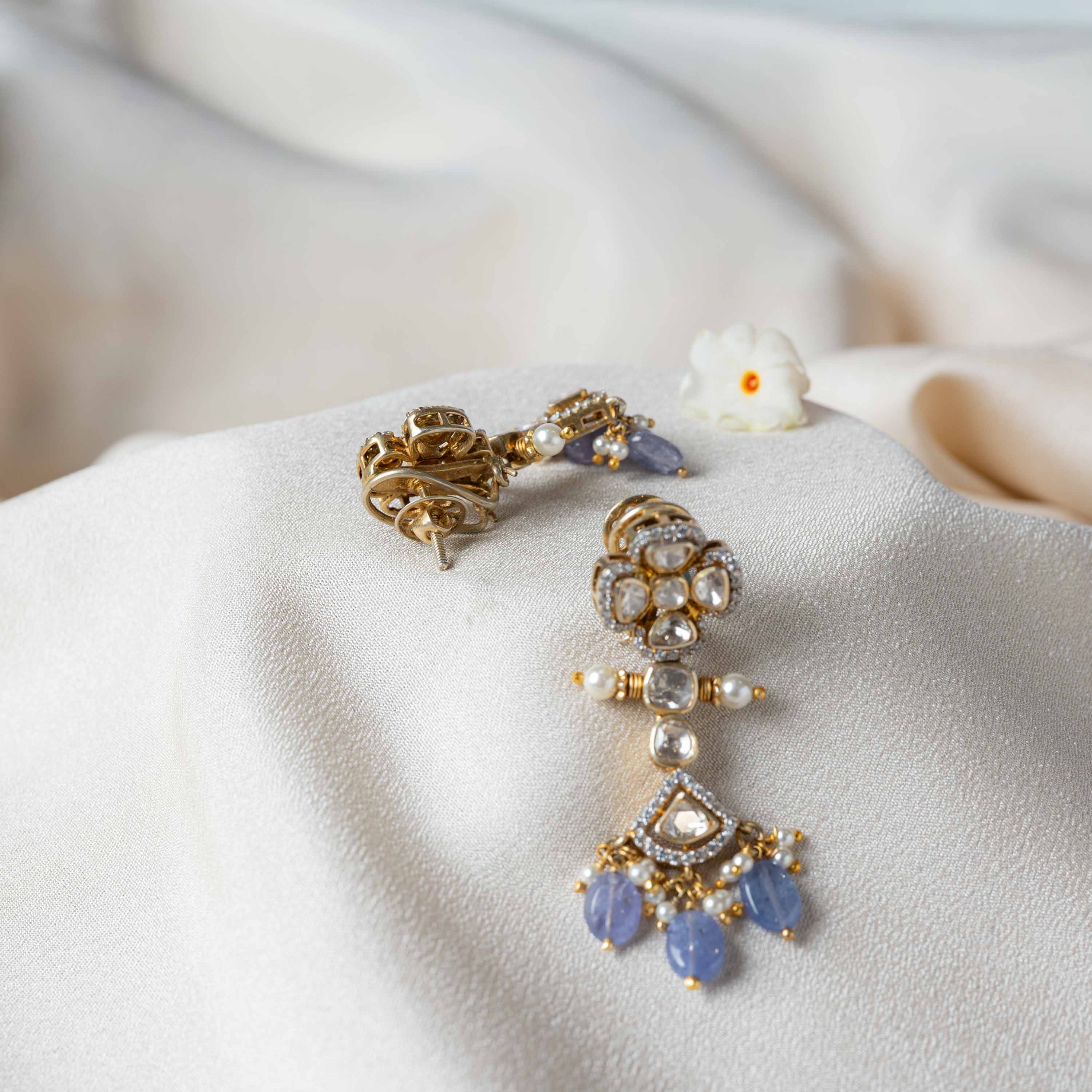 Side view of Niya Polki Hangings showcasing gold-plated 925 silver craftsmanship with Moissanite Polki, sparkling CZ detailing, pearls and pastel strawberry bead fringe.