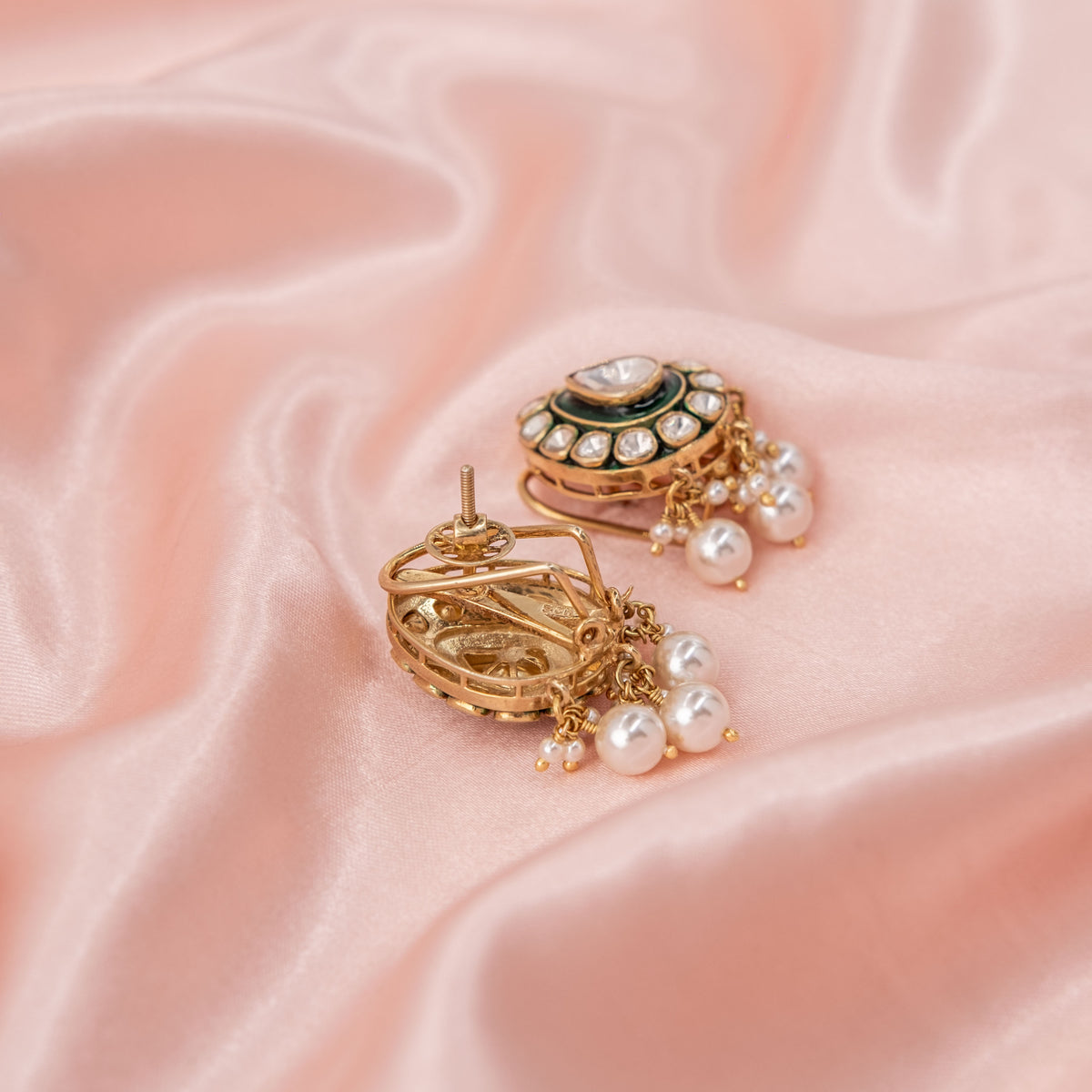 Screw back and clip behind the paisley polki earring with its pearl fringe, gold plated silver