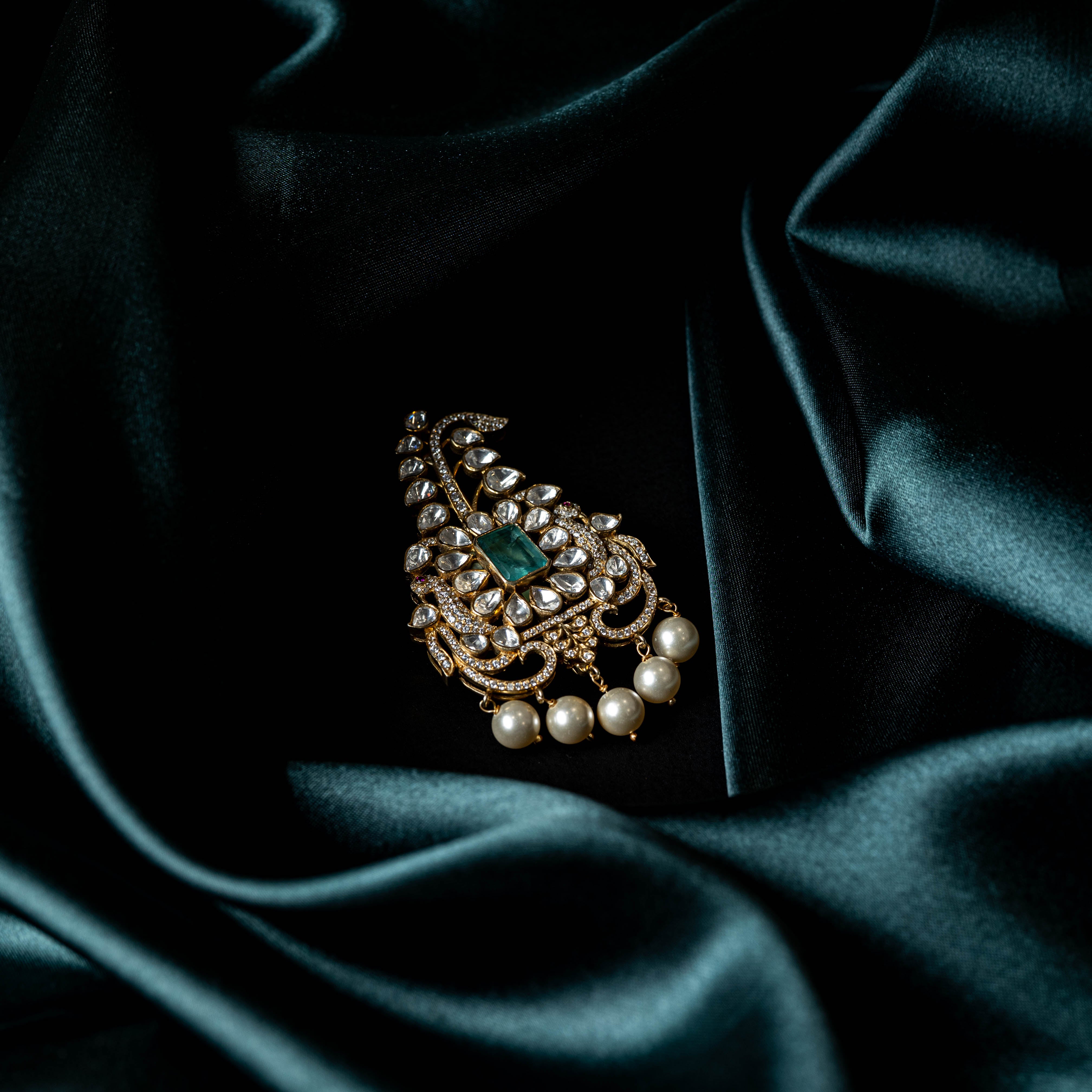Close view of the polki leaf tiers and hanging pearl drops on the Victorian plated kalangi