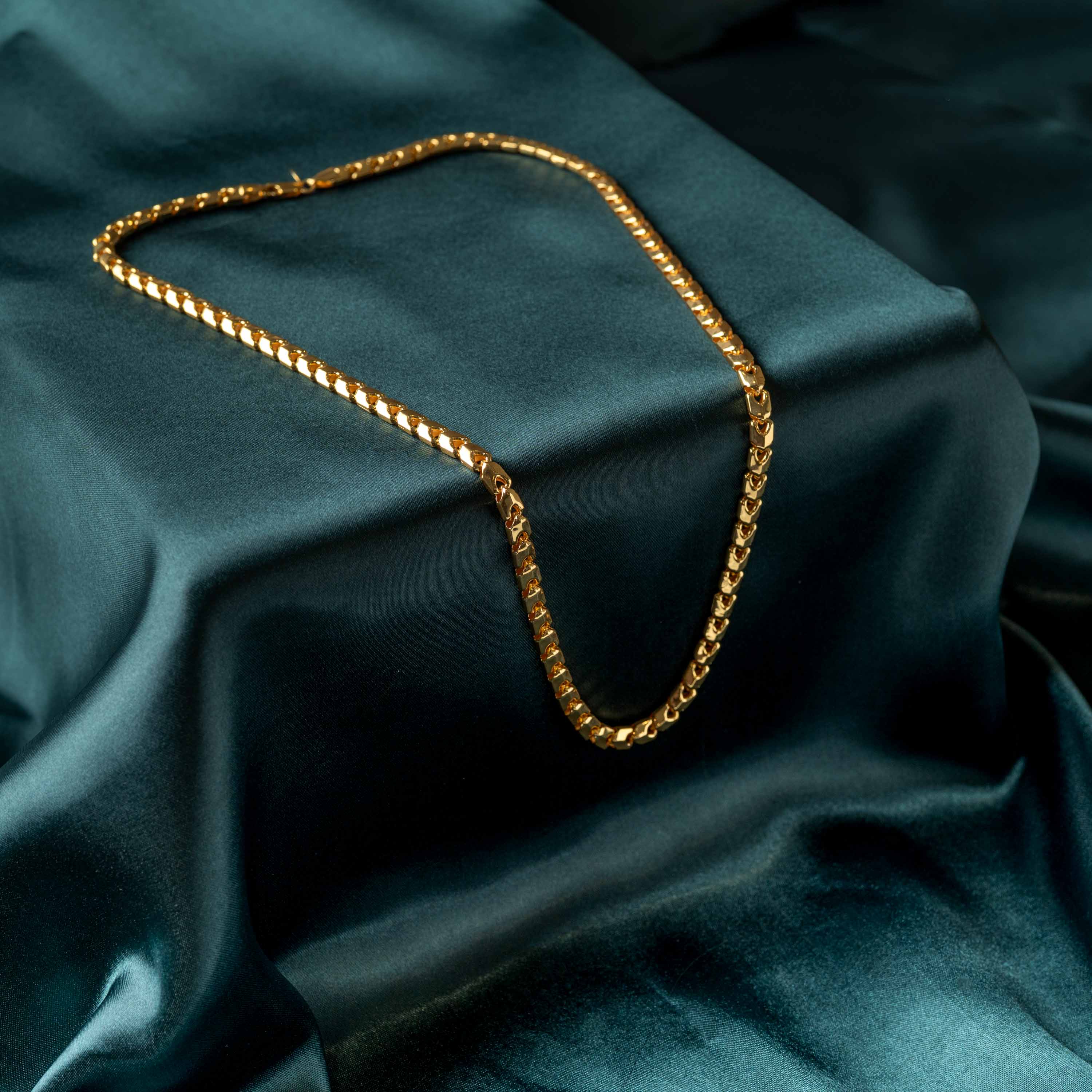 Box link neckchain for men in gold plated 925 silver with a lobster clasp, laid on teal satin