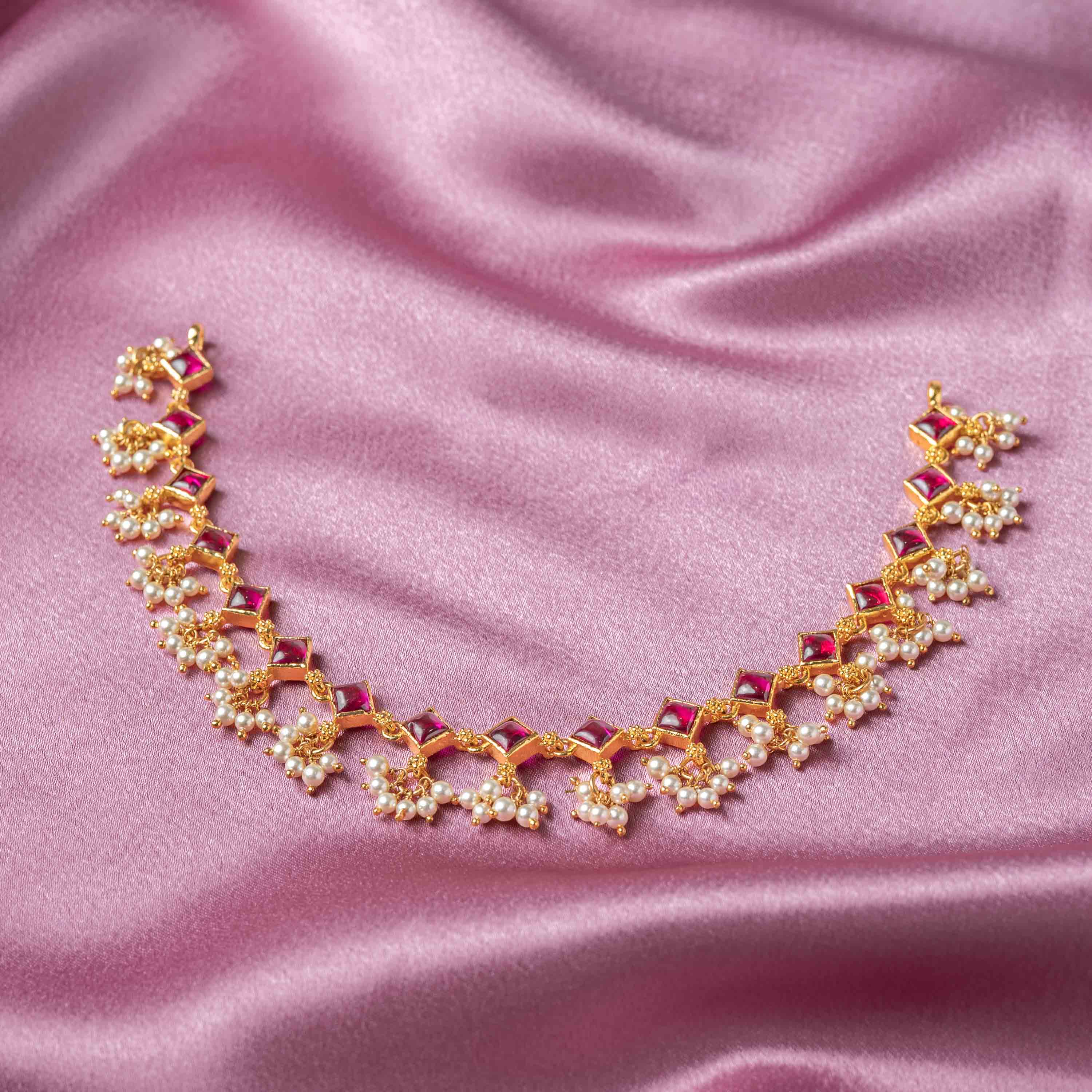Close-up of Ruchira CZ Necklace featuring emerald stones, sparkling CZ stones and Swarovski pearl drops in 925 silver with gold plating