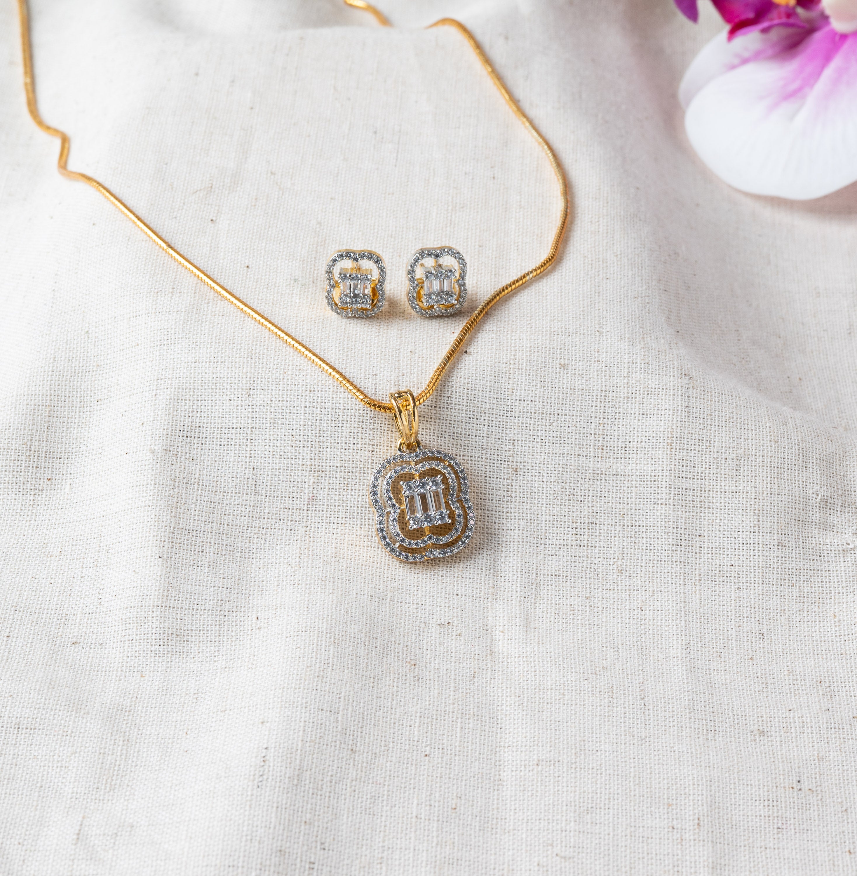Stud pair in close crop, baguette CZ centres inside a round CZ halo, gold plated 925 silver
