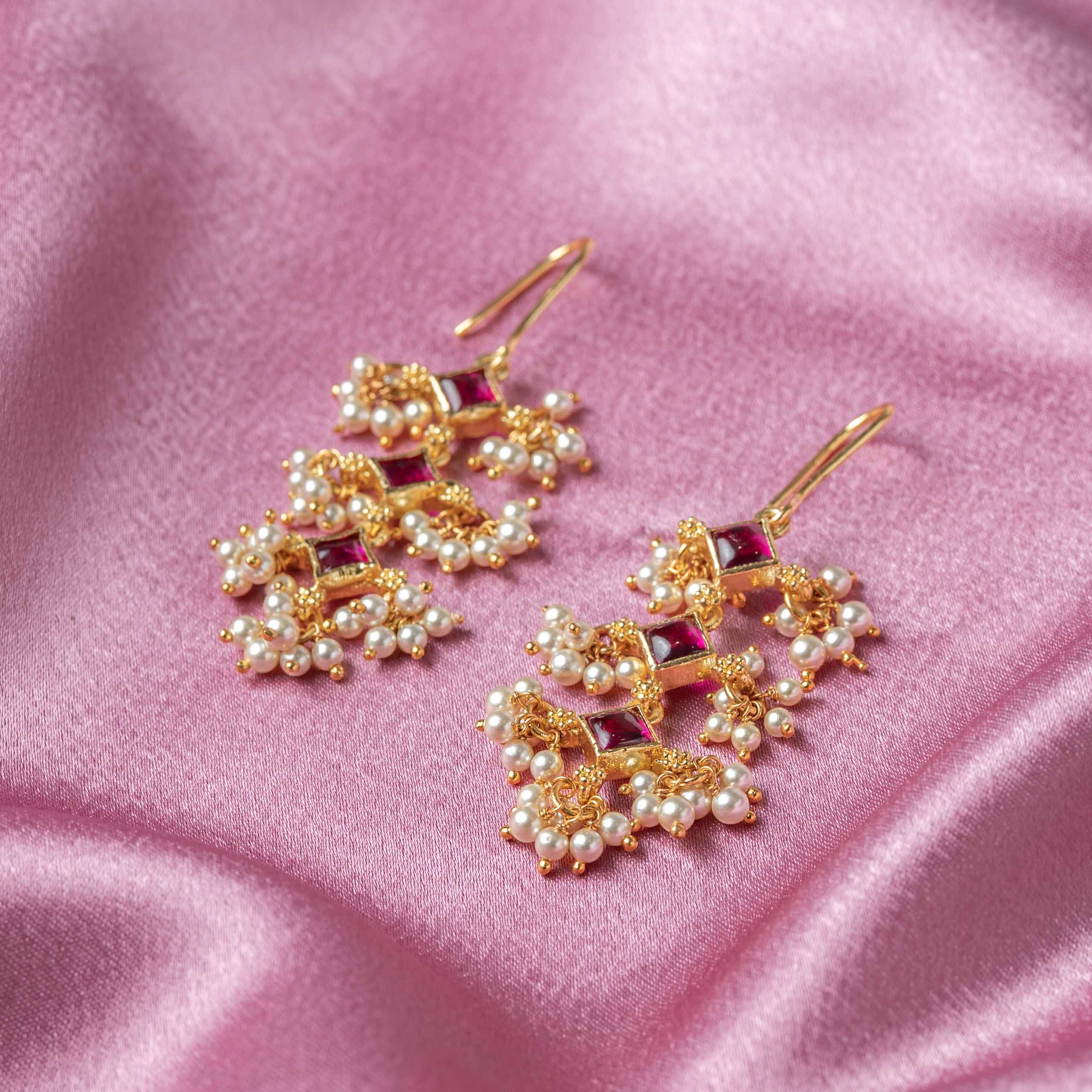 Close-up of Ruchira CZ Hanging earrings featuring semi-precious emeralds, sparkling CZ stones and Swarovski pearls
