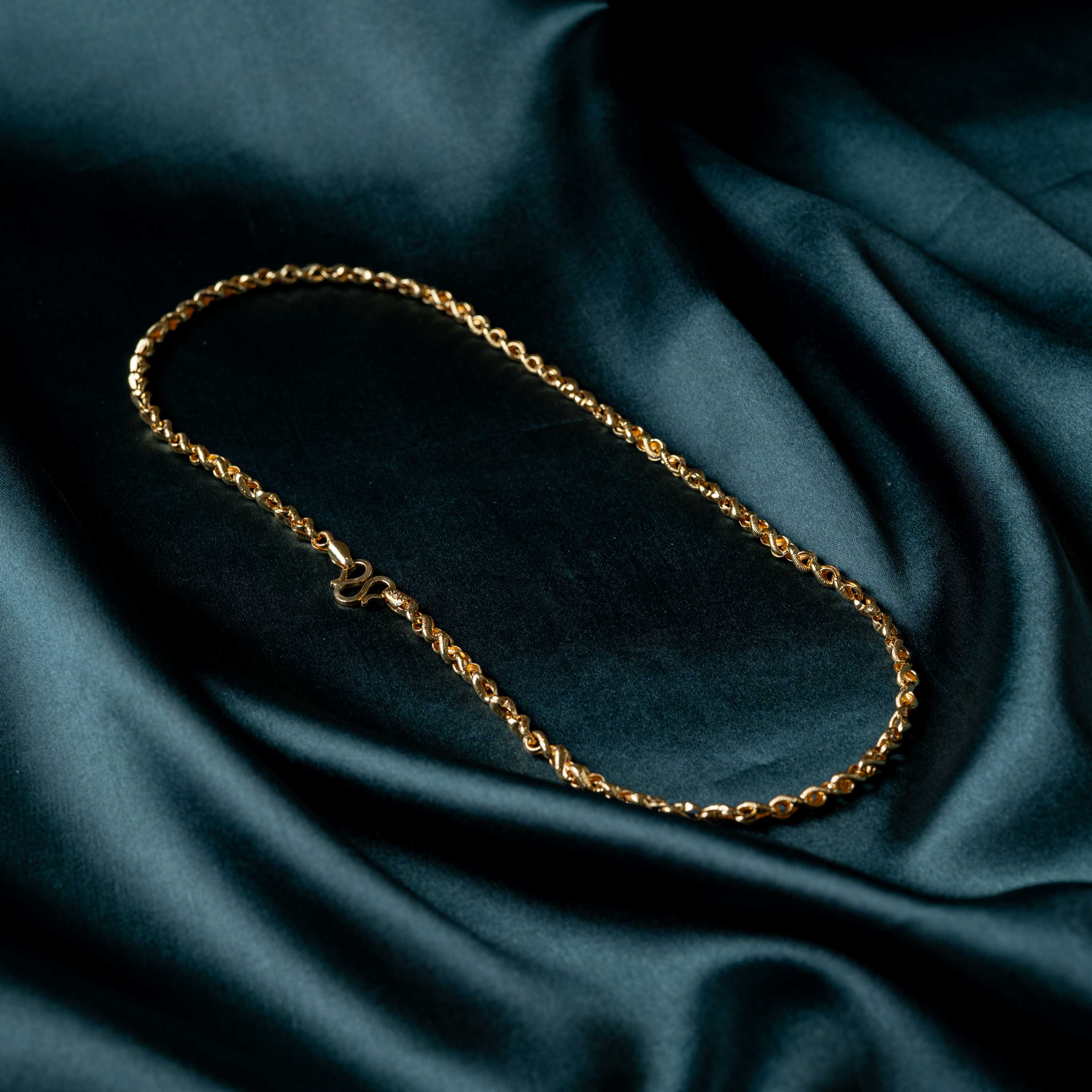 Full length of the rope twist chain laid in a loop on satin, gold plated 925 silver