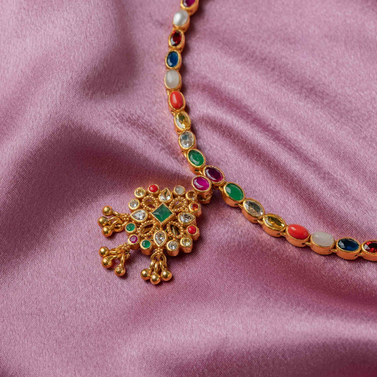 White CZ pave face of the double side necklace with its red glass centre in gold plated silver