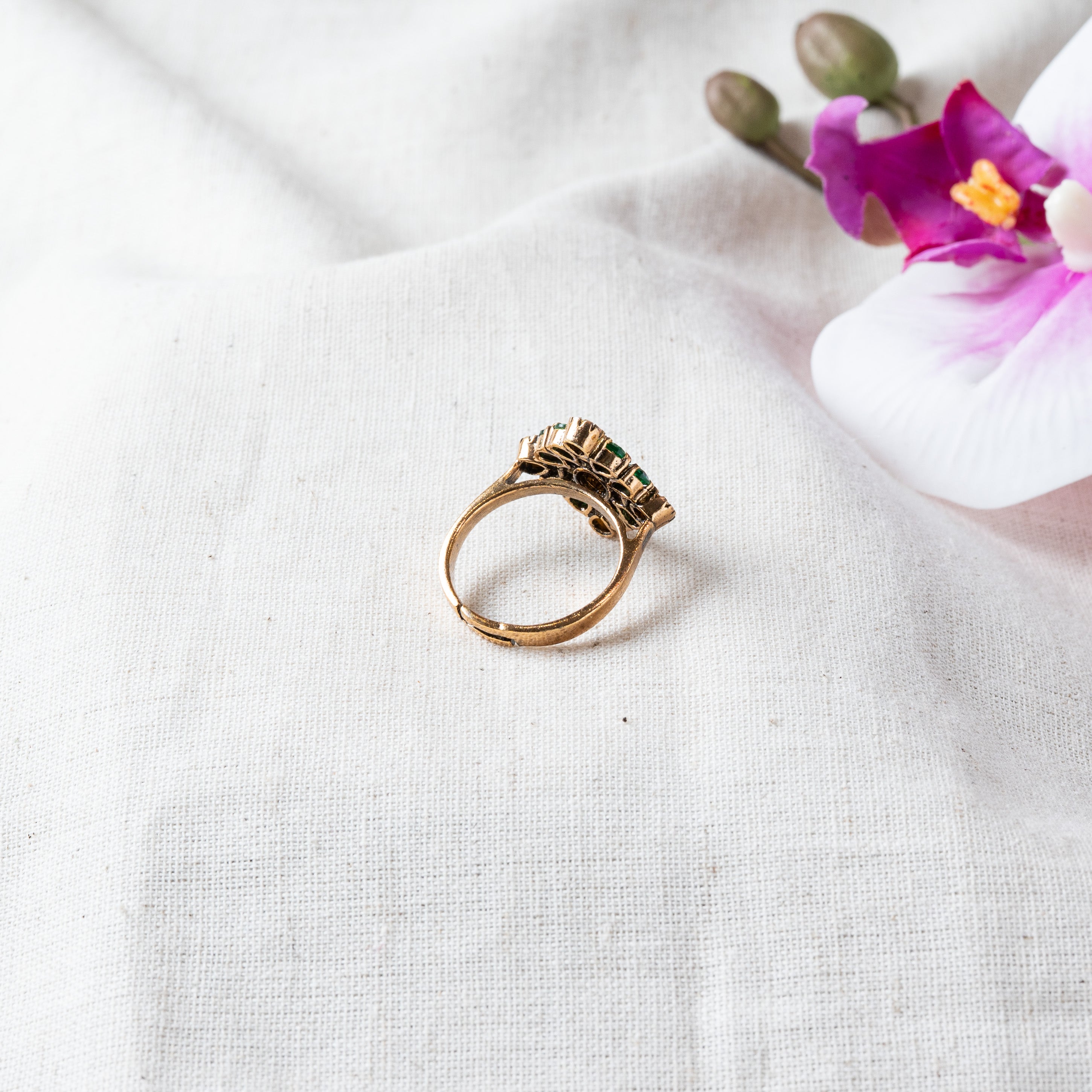 Angled view of the emerald and rose cut stone cluster set in gold plated 925 silver