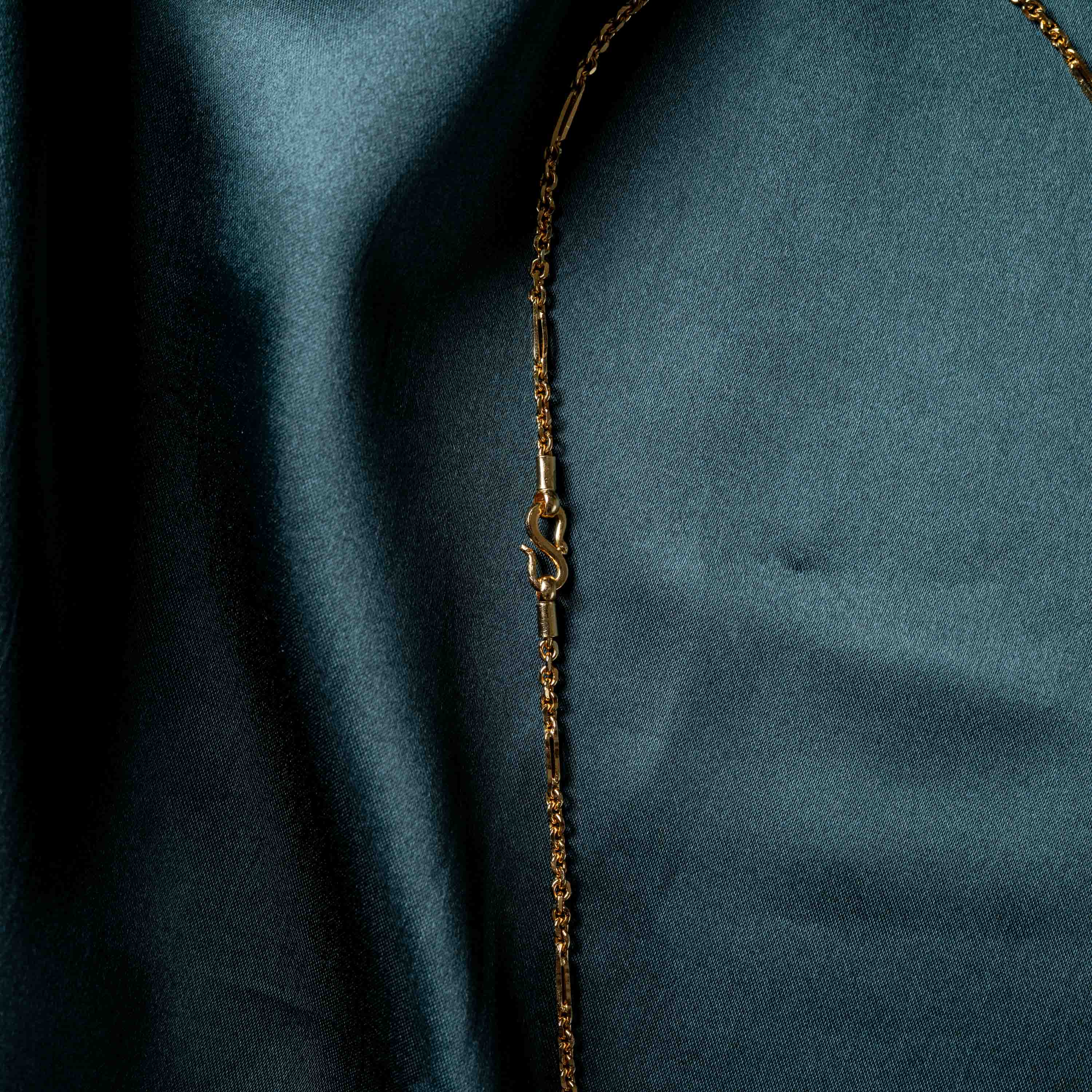 Close crop of the S hook clasp beside the bar links, gold plated 925 silver