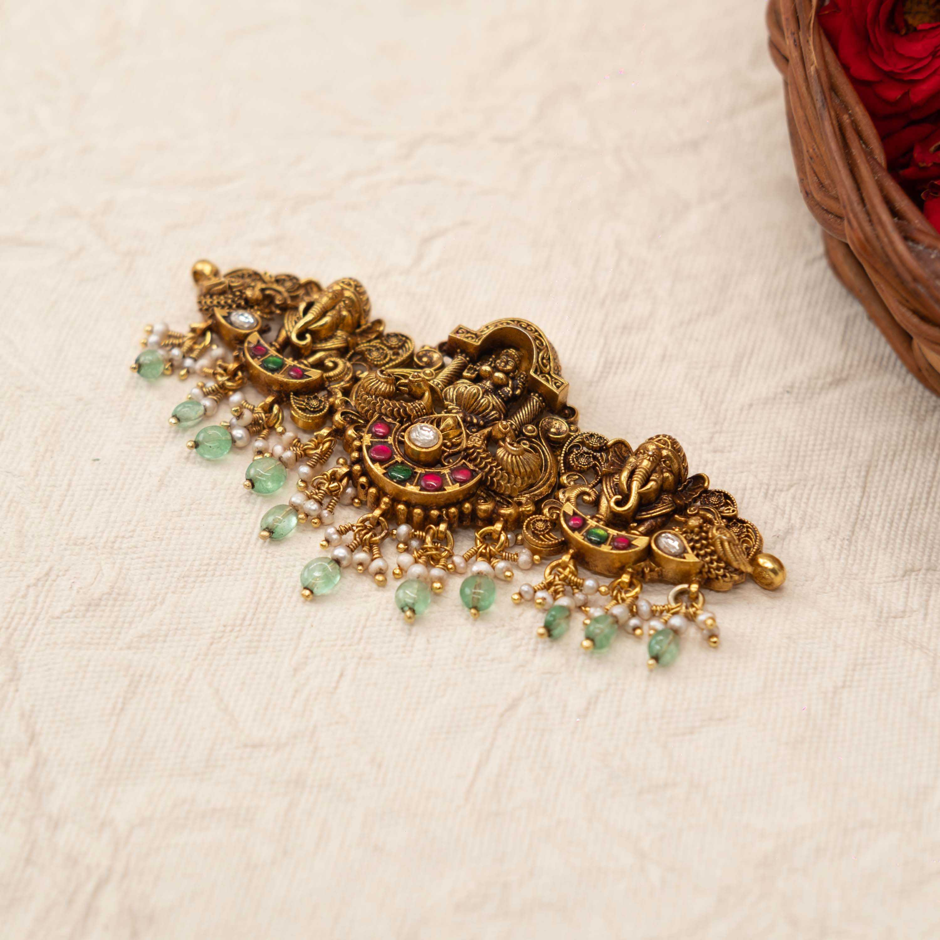 Green bead and seed pearl fringe below the antique gold Lakshmi panel, seen at an angle