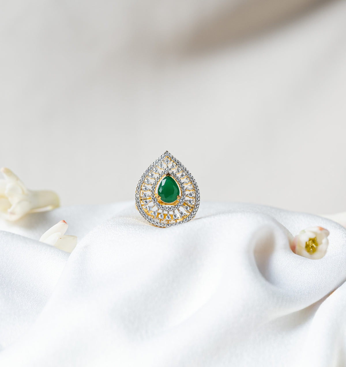 Teardrop cocktail ring with a green pear cut stone in a CZ pave halo on gold plated 925 silver