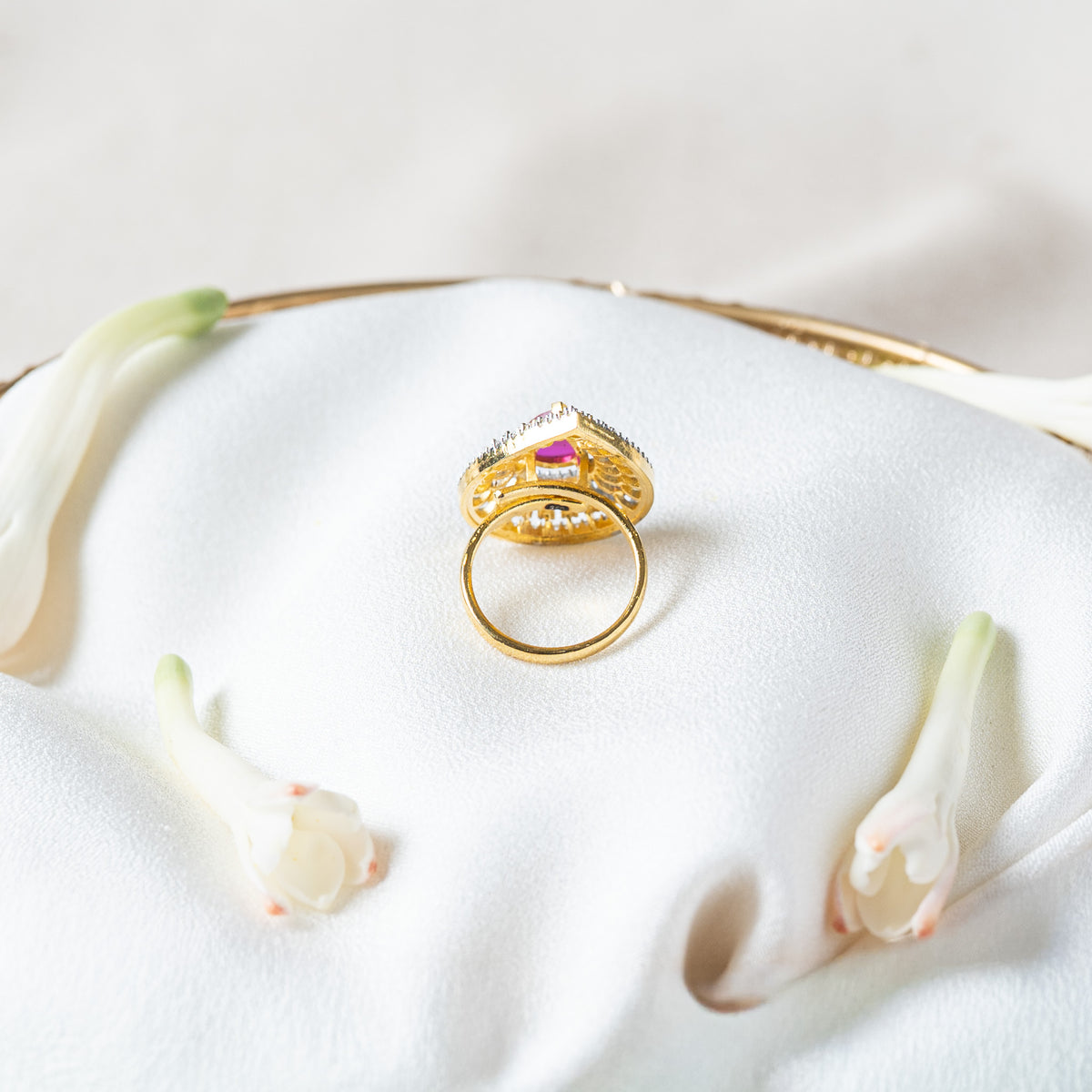 Reverse of the pink teardrop ring showing the continuous gold band, a fixed ring size