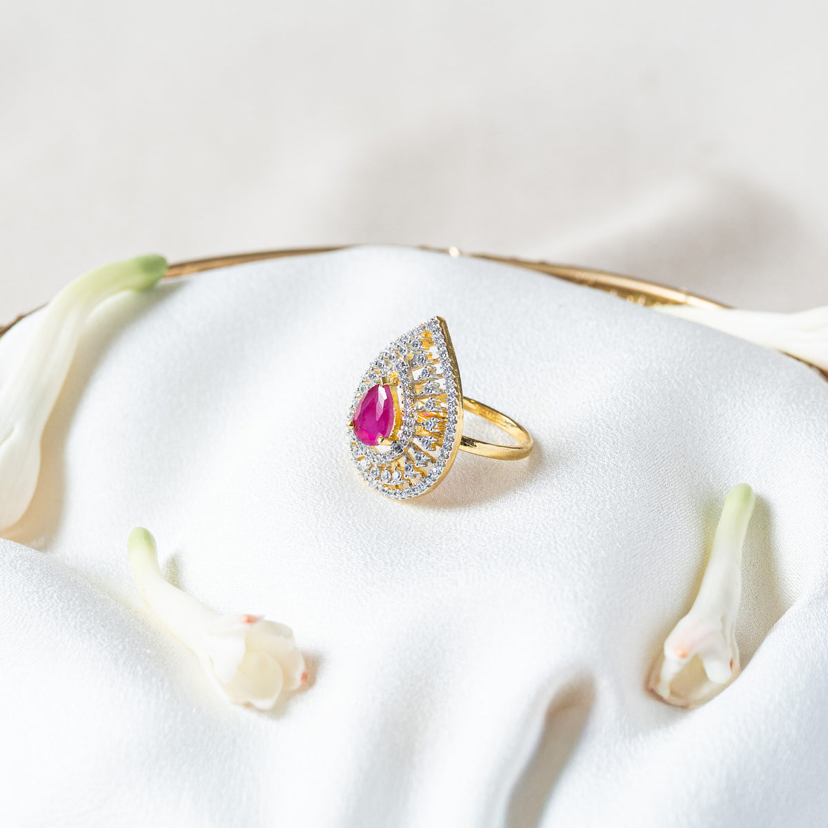 Angled view of the pink teardrop ring showing the height of the prong set centre stone