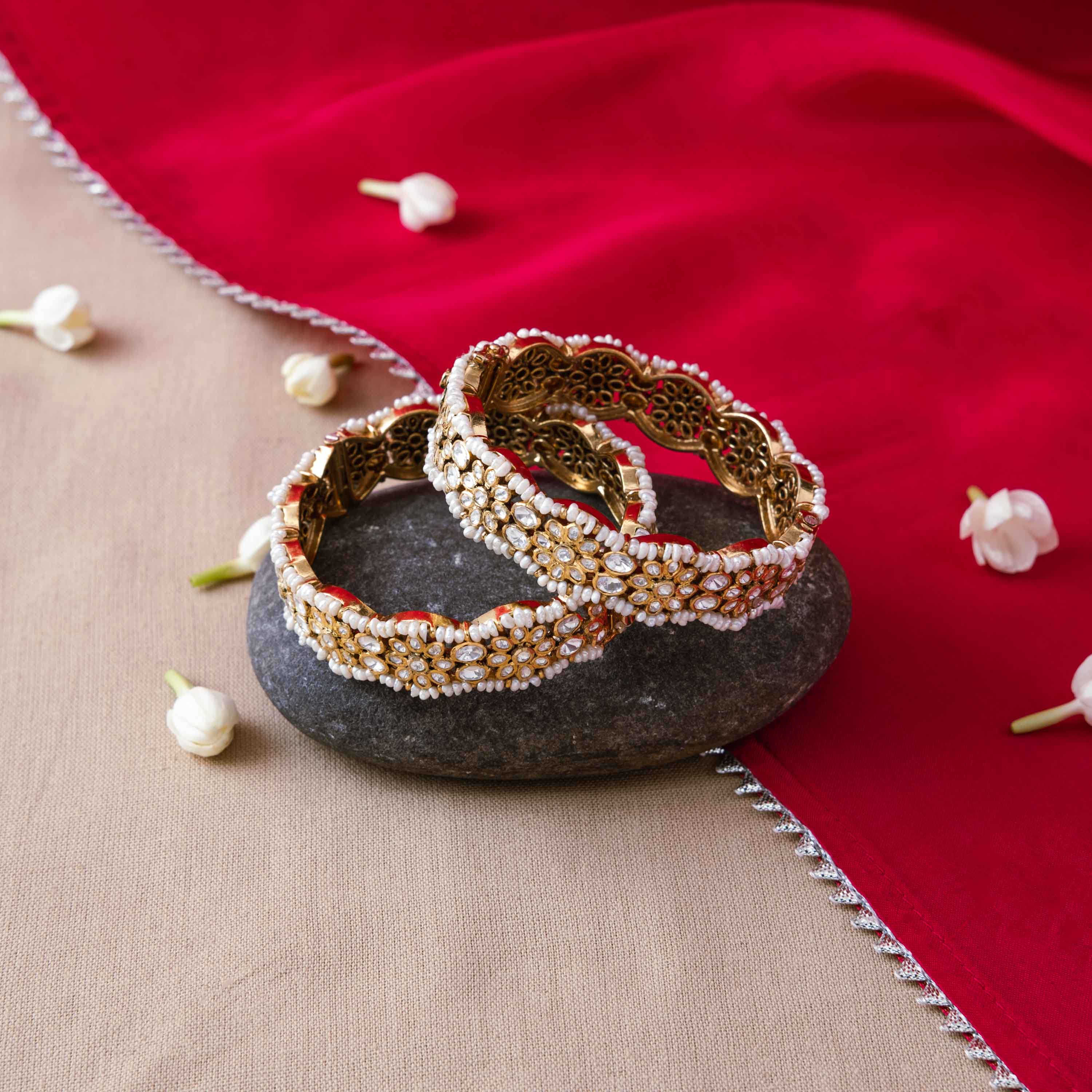 Rows of rice pearls set around white polki florets on a gold plated 925 silver bangle